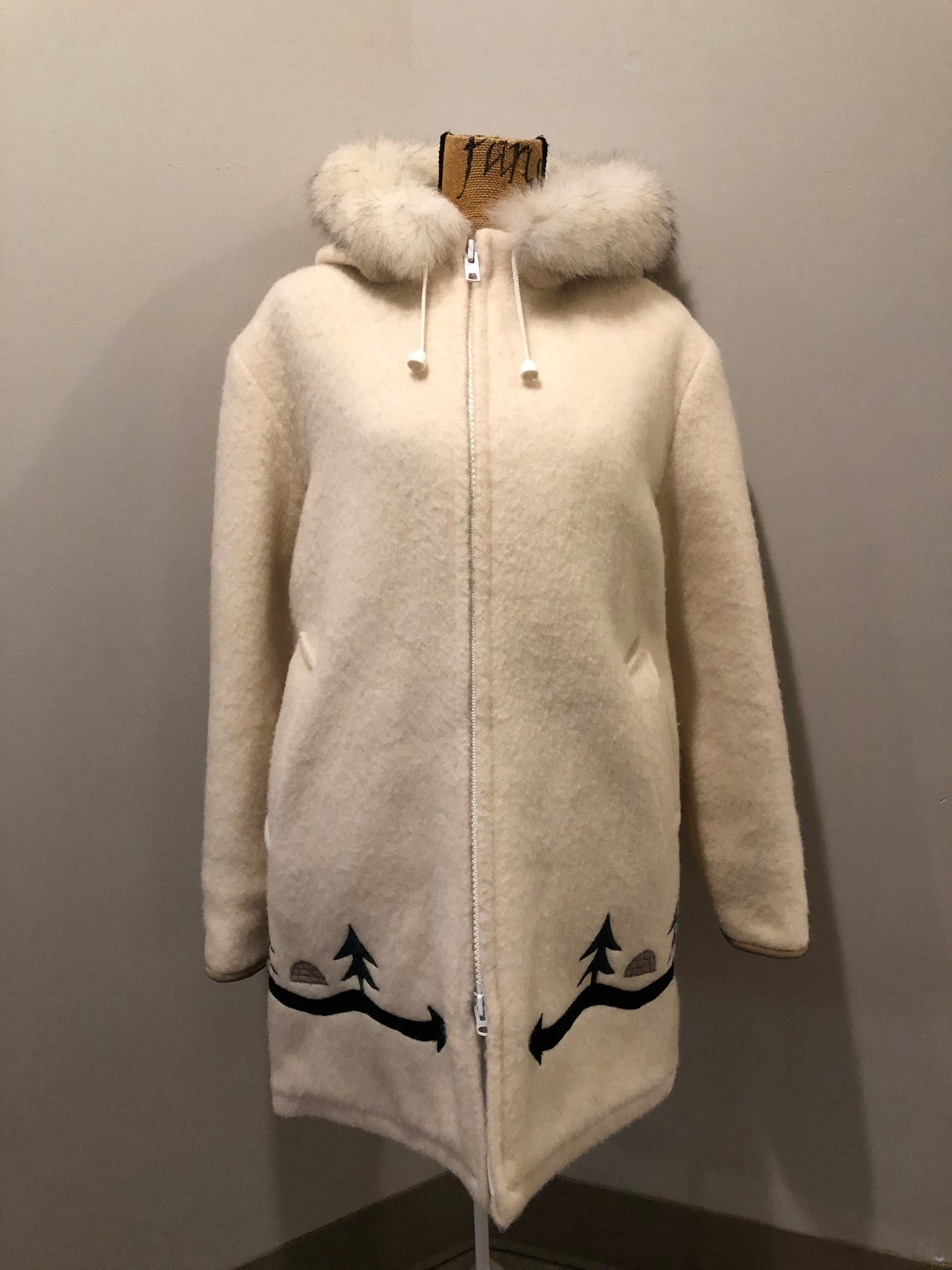 Kingspier Vintage - Hudson’s Bay Company white pure virgin wool northern parka featuring a hood with fox fur trim, zipper closure, quilted lining, inside drawstring, slash pockets, hidden knit cuffs and tree a nd igloo design suede appliqué on the front and back. Made in Canada. Size 14/ large.