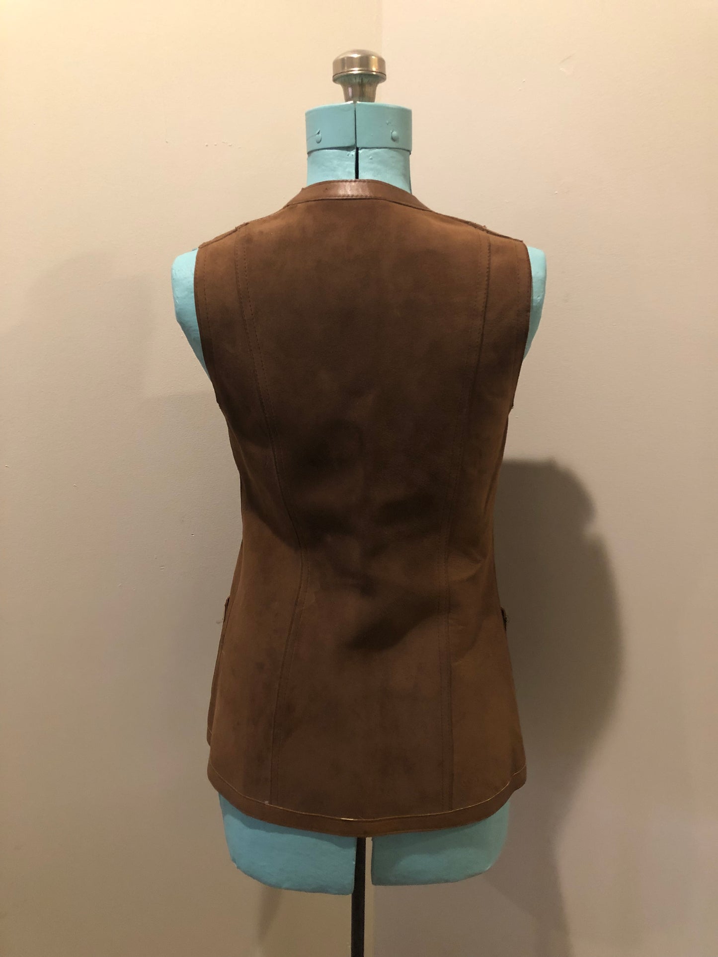 Vintage Mills Brothers deadstock 1960’s brown suede vest with large gold geometric front clasp, leather lining and trim and two patch pockets in the front. Suede and leather are buttery soft. Made in England - Kingspier Vintage