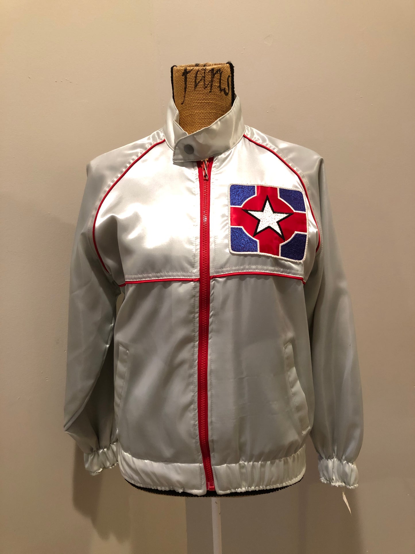 Kingspier Vintage - Milk and Honey - John Lennon and Yoko Ono Roadie Tour Jacket from the mid 1980’s. A very rare collectors piece from John Lennon’s last studio album. Jacket is light grey nylon with satin effect with two slash pockets, elastic waist and cuffs, chunky red zip up front with popper at the collar. The jacket features a star logo on the front and Milk and honey logo on the back with a rainbow. Made in the USA. Size XS.