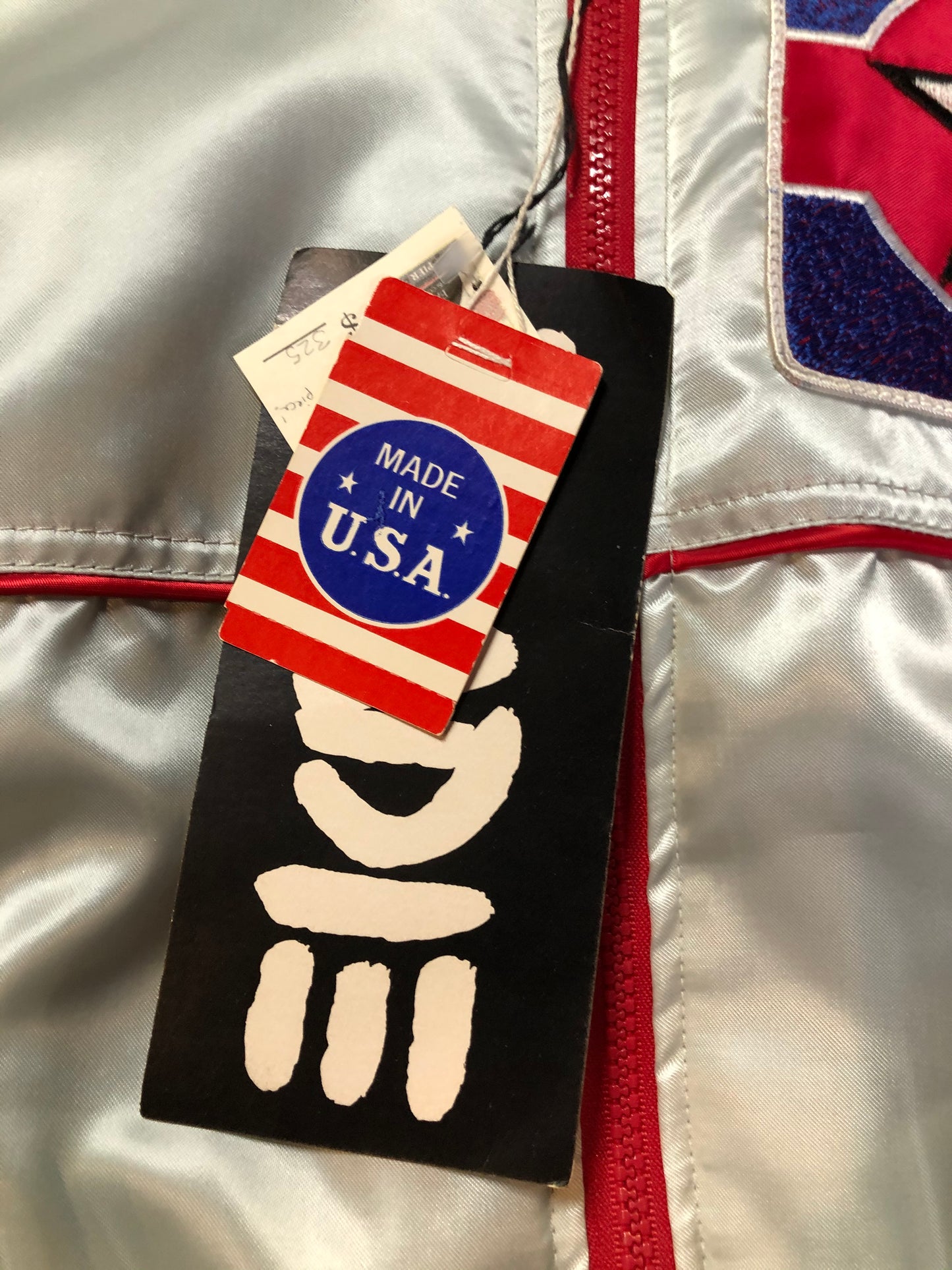 Kingspier Vintage - Milk and Honey - John Lennon and Yoko Ono Roadie Tour Jacket from the mid 1980’s. A very rare collectors piece from John Lennon’s last studio album. Jacket is light grey nylon with satin effect with two slash pockets, elastic waist and cuffs, chunky red zip up front with popper at the collar. The jacket features a star logo on the front and Milk and honey logo on the back with a rainbow. Made in the USA. Size XS.