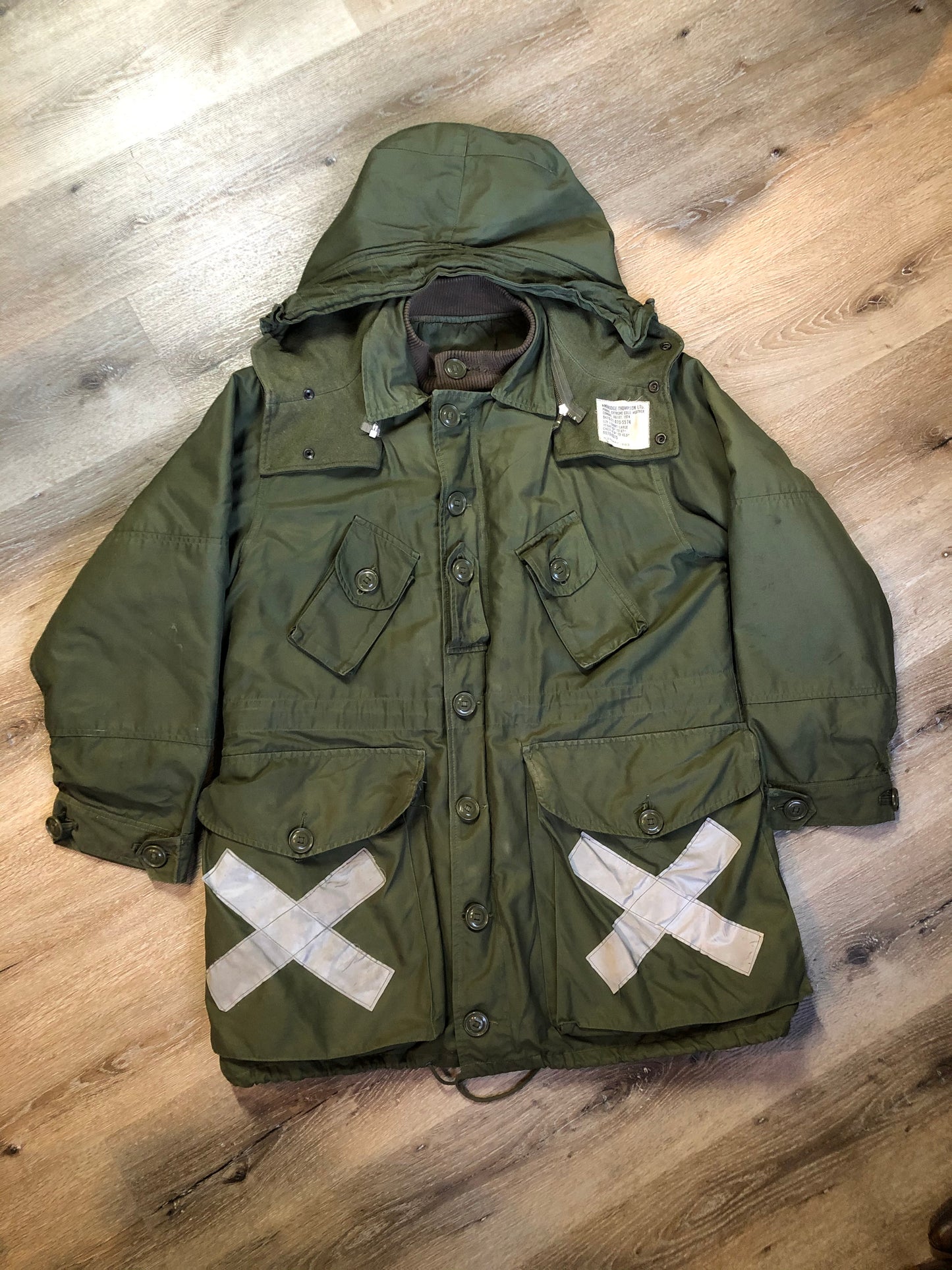 Kingspier Vintage - Canadian military surplus extreme cold parka in army green. The parka features zipper and buttons closure, flap pockets, knit collar, detachable hood, removable quilted lining and bottom hem drawstring. Size large.