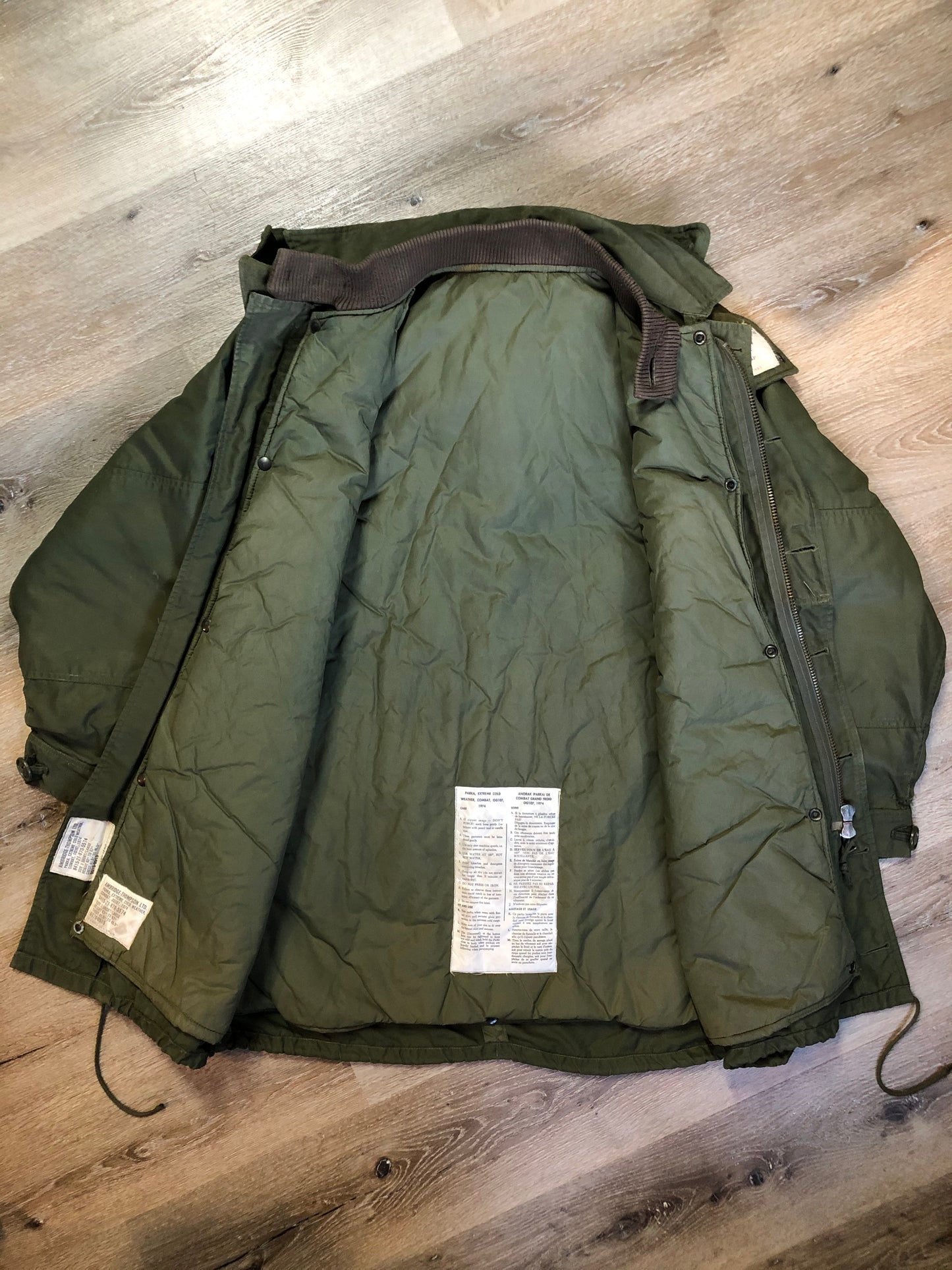 Kingspier Vintage - Canadian military surplus extreme cold parka in army green. The parka features zipper and buttons closure, flap pockets, knit collar, detachable hood, removable quilted lining and bottom hem drawstring. Size large.
