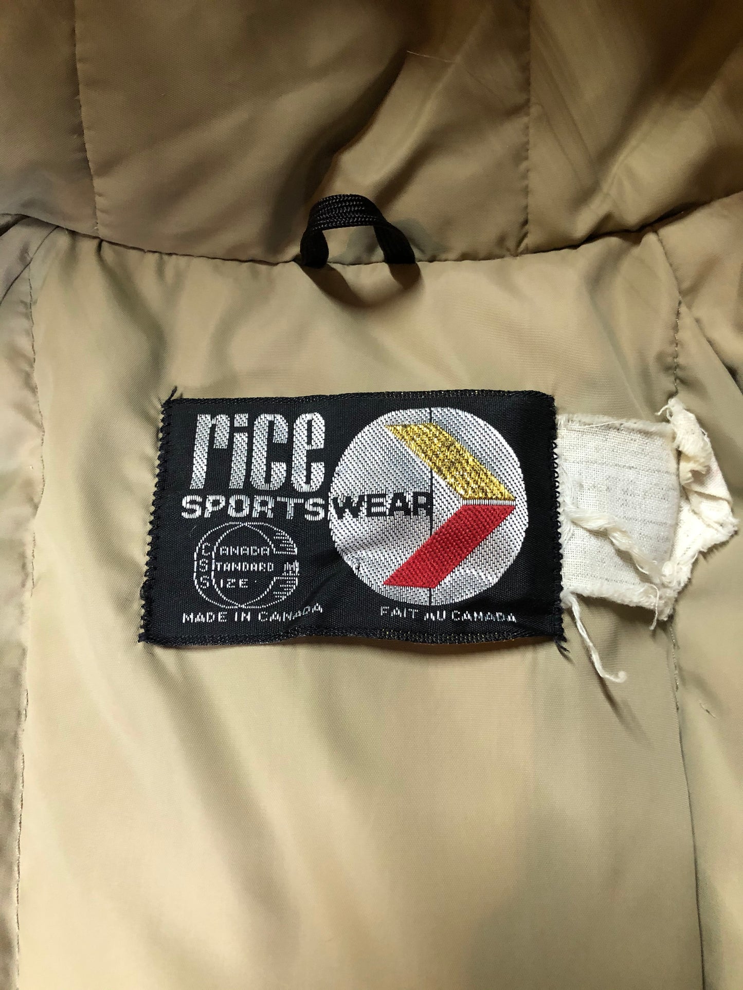 Kingspier Vintage - Vintage Rice Sportswear beige down-filled parka, with a fox fur trimmed hood. This exceptionally warm parka has embroidered ribbon detail in the cuffs and bottom hem. Parka features zipper and ribbon button closures, flap pockets and handwarmer pockets, Size medium. Made in Canada.