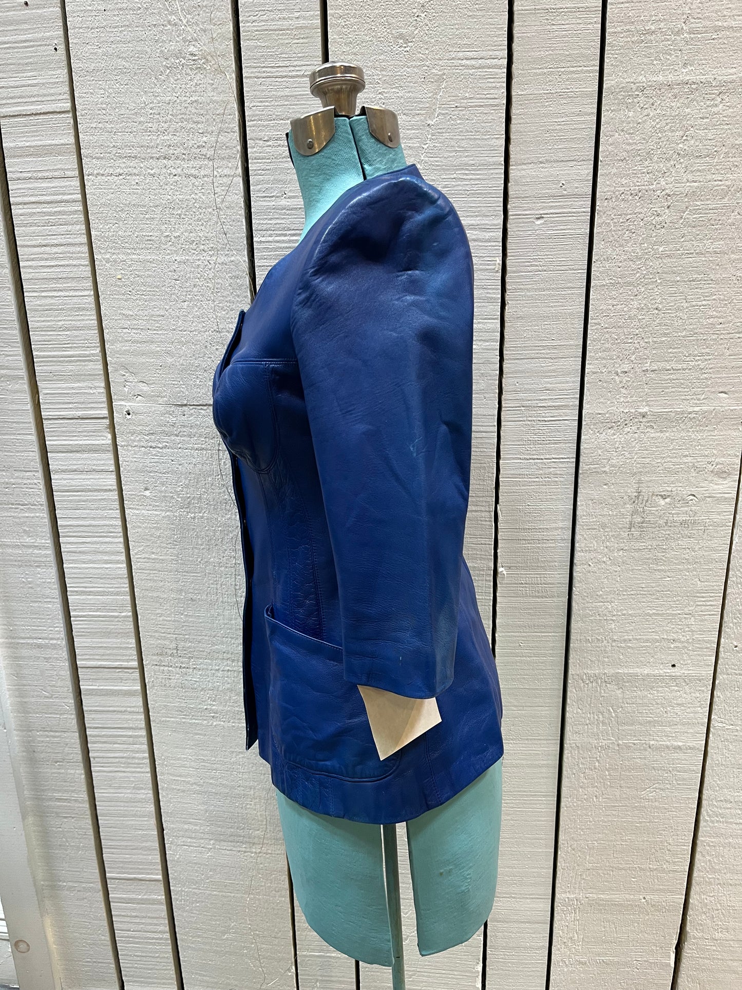 Vintage purple leather jacket/ top with snap closures, chest cups, slight shoulder padding and two front patch pockets.
Chest 33”