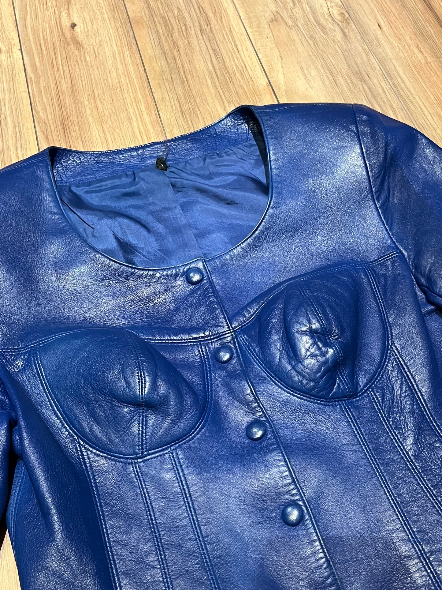 Vintage purple leather jacket/ top with snap closures, chest cups, slight shoulder padding and two front patch pockets.
Chest 33”