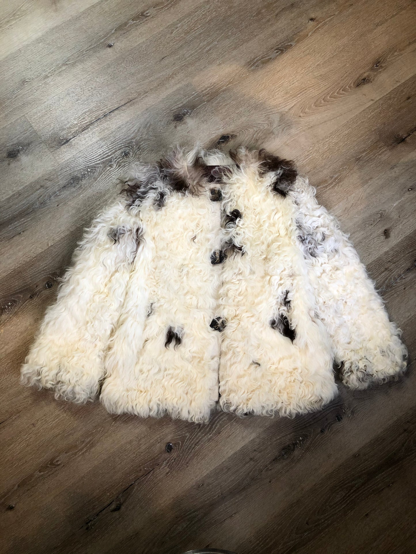 Kingspier Vintage - Vintage Mongolian sheepskin coat with soft and curly white and brown fur, pockets, pink satin lining, unique buttons and leather frog closures. Size small.