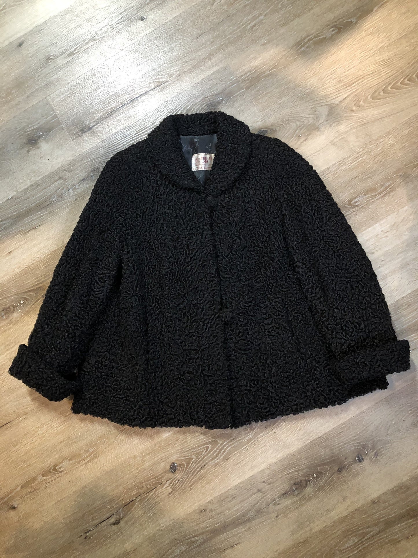 Kingspier Vintage - Vintage Rideau Furs black persian wool coat with wool buttons, pockets and black satin lining with delicate flower motif. Made in Nova Scotia. Size small/ medium.