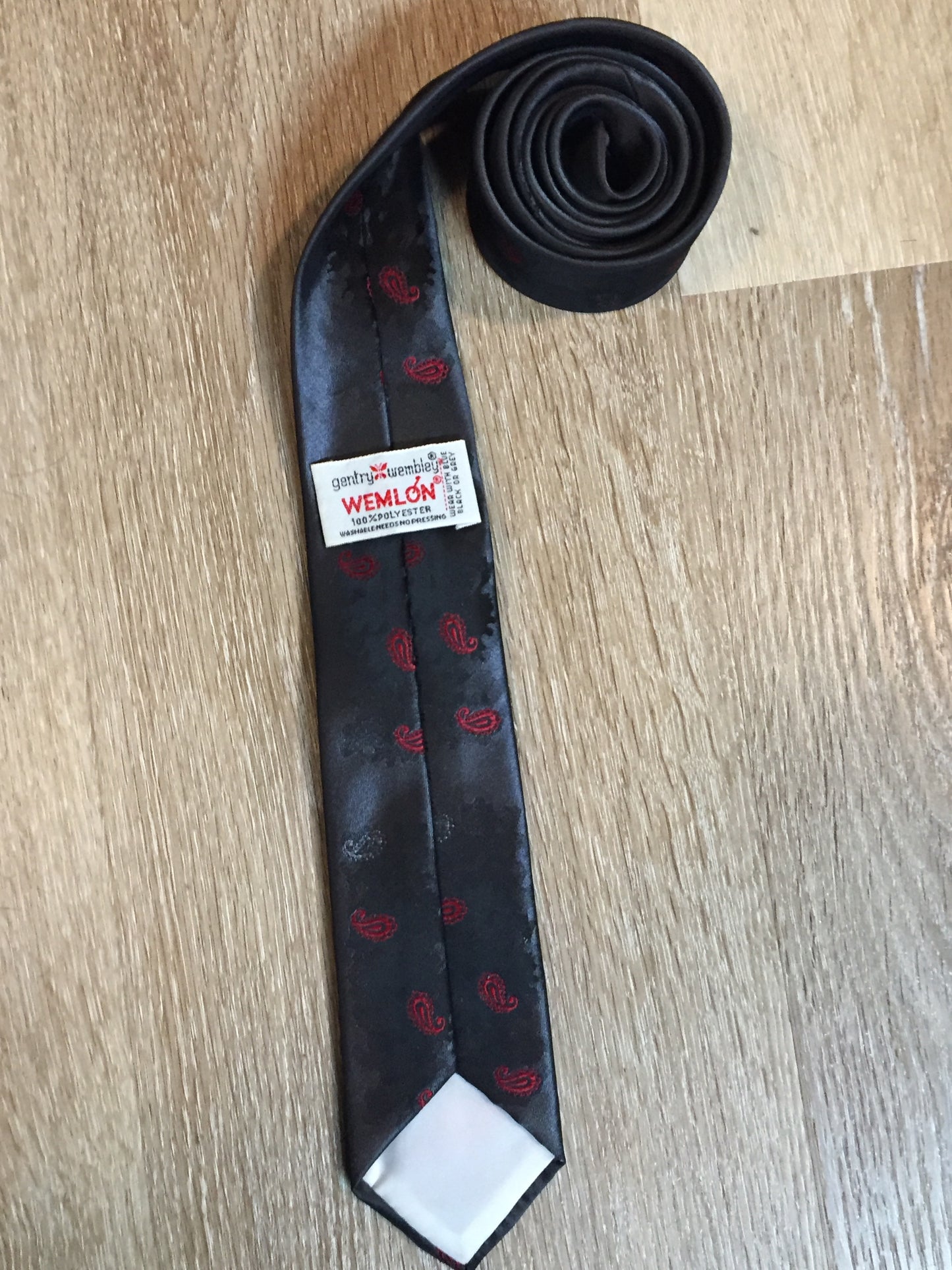 Kingspier Vintage - Gentry Wembly “Wemlon” vintage 100% polyester grey, black and red subtle paisley pattern tie.
Length: 54”
Width: 2.5”
This tie is in excellent condition.