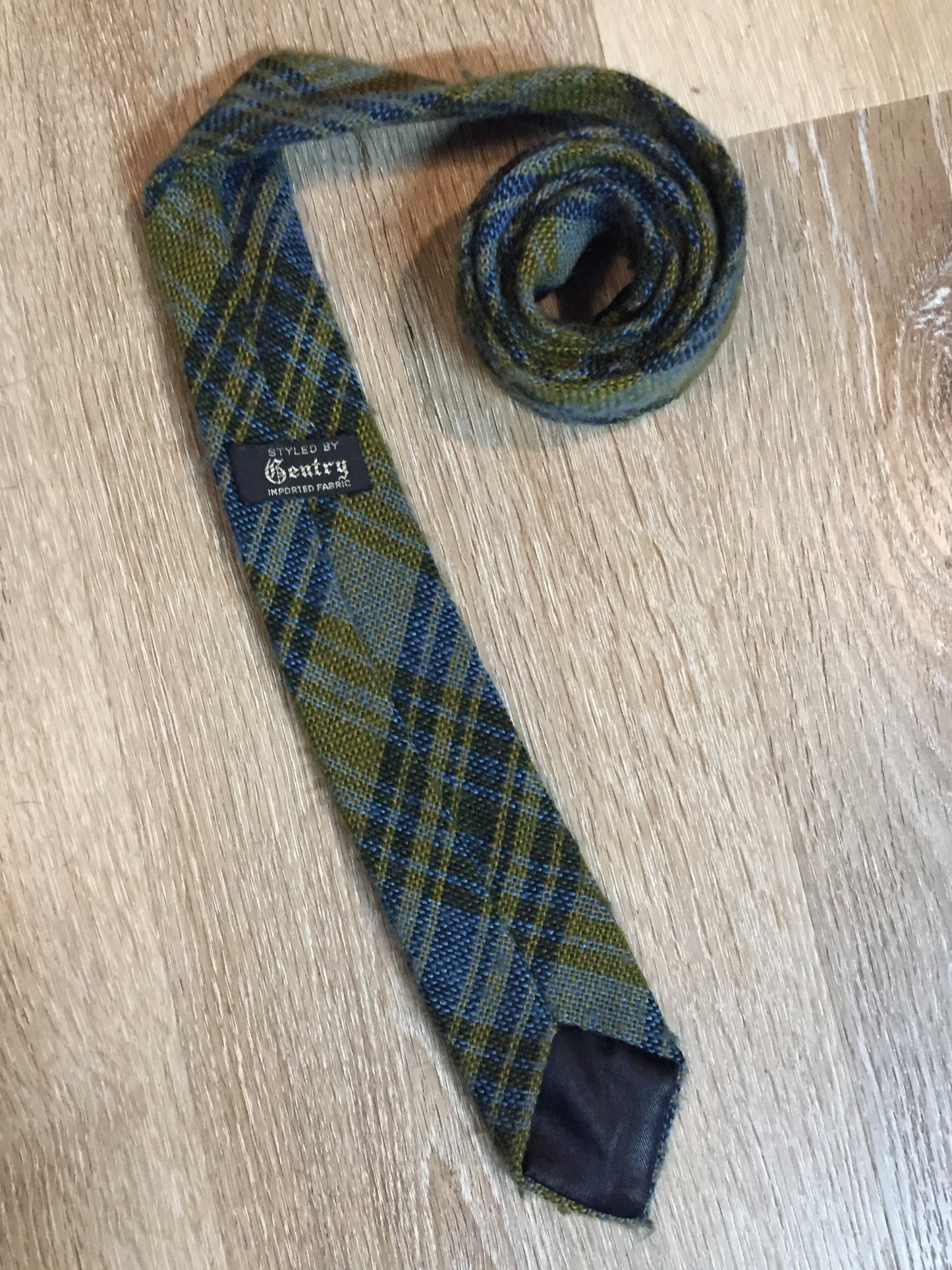 Kingspier Vintage - Gentry vintage 100% wool tie with blue and yellow plaid design.
 
Length: 59”
Width: 2.5”
This tie is in excellent condition.