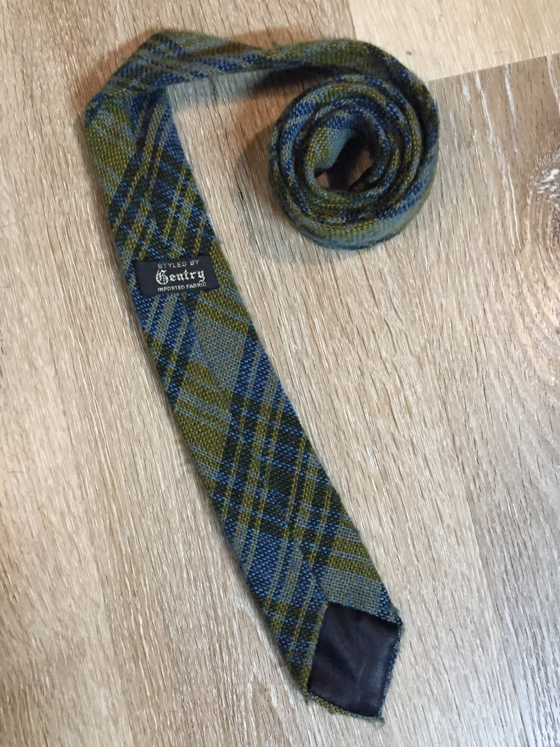 Kingspier Vintage - Gentry vintage 100% wool tie with blue and yellow plaid design.
 
Length: 59”
Width: 2.5”
This tie is in excellent condition.