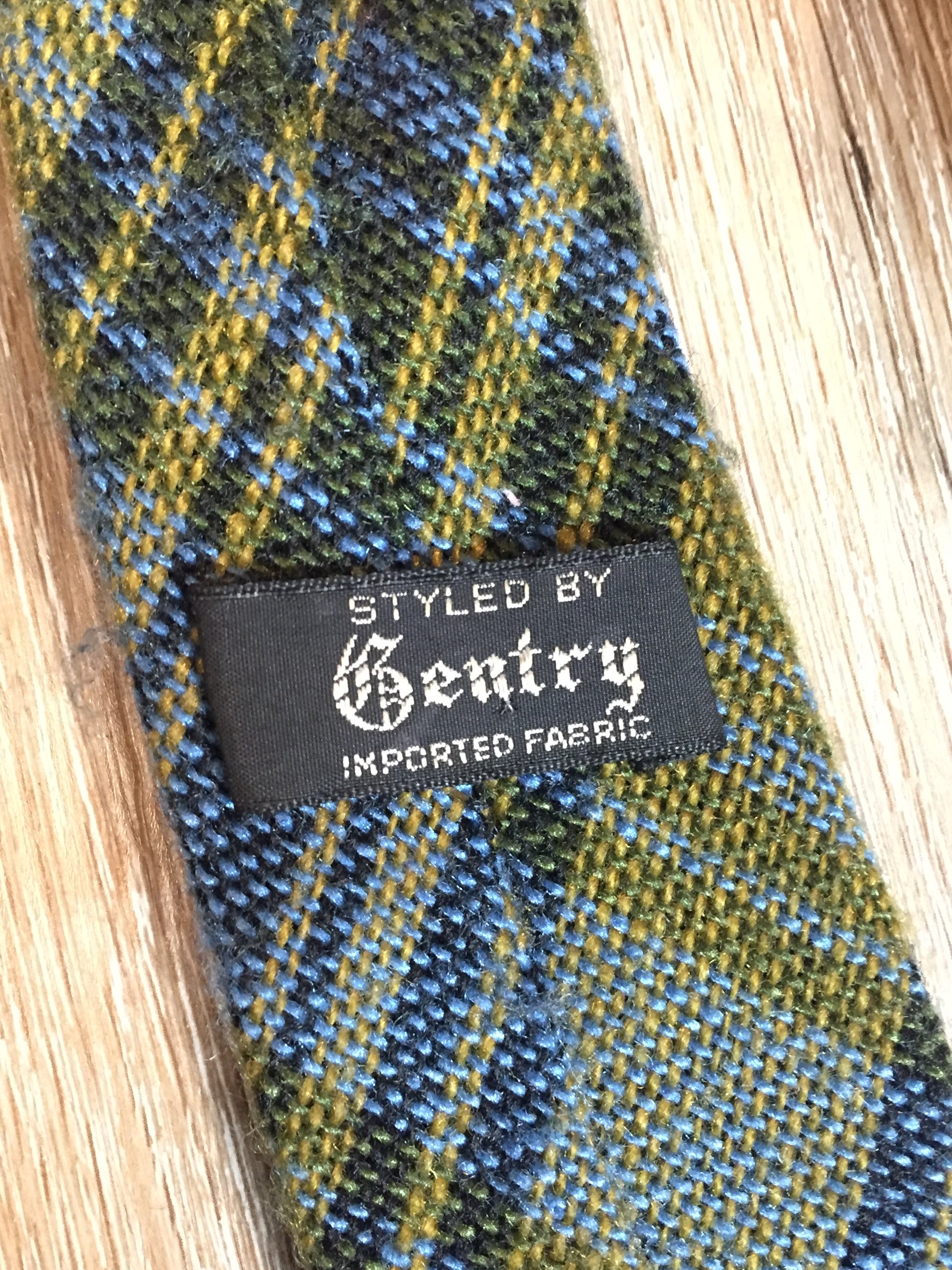Kingspier Vintage - Gentry vintage 100% wool tie with blue and yellow plaid design.
 
Length: 59”
Width: 2.5”
This tie is in excellent condition.