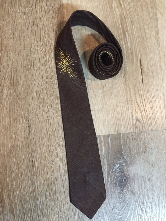 Kingspier Vintage - Frank Struser Original Necktie in brown with gold starburst design. Fibres unknown.
Length: 56.6” 
Width: 2.5” 
This tie is in excellent condition.