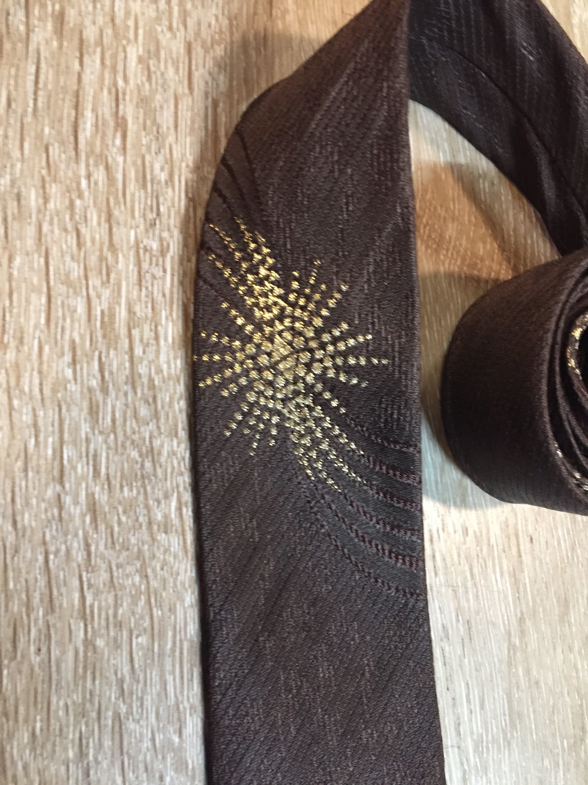 Kingspier Vintage - Frank Struser Original Necktie in brown with gold starburst design. Fibres unknown.
Length: 56.6” 
Width: 2.5” 
This tie is in excellent condition.