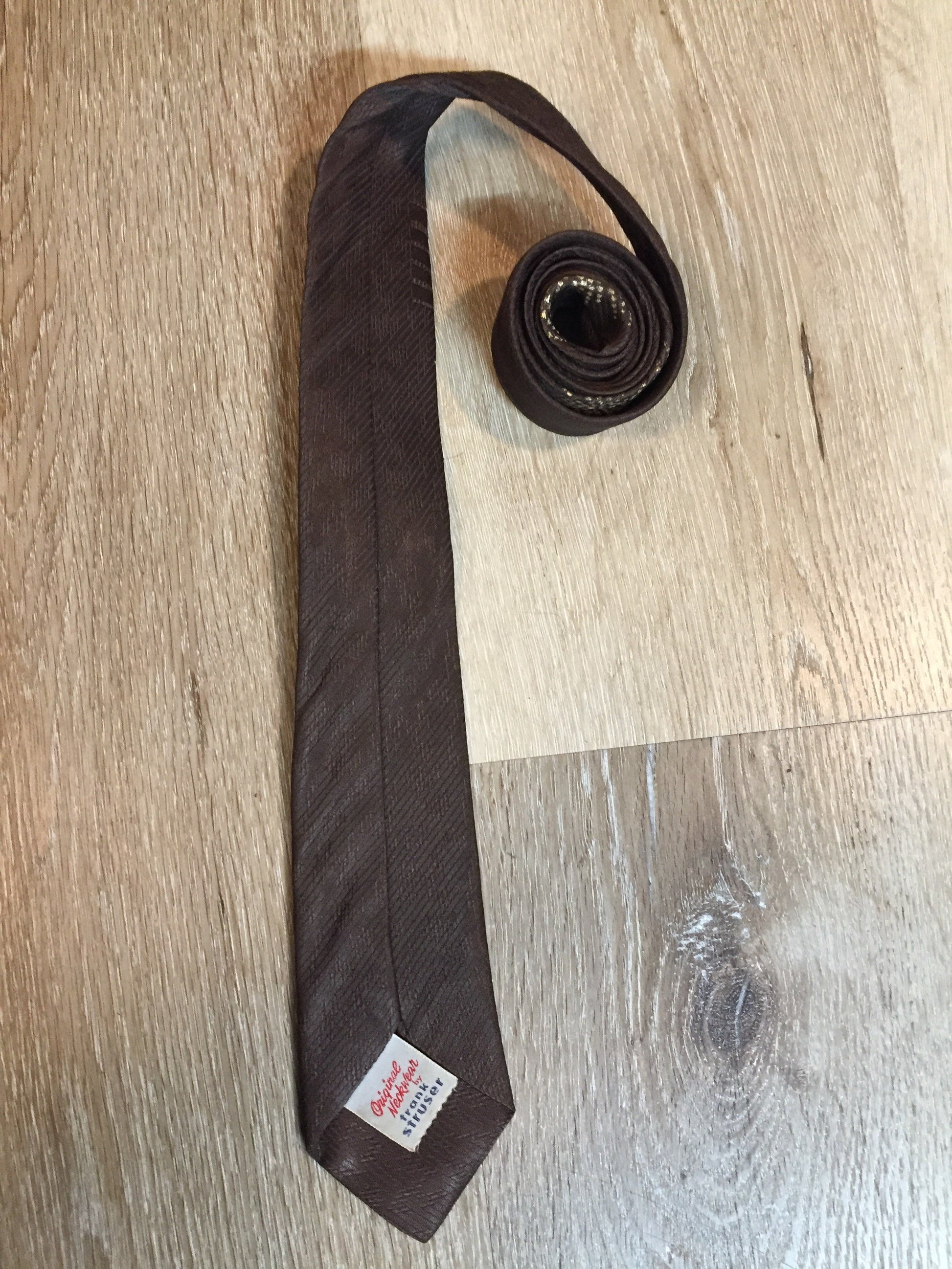 Kingspier Vintage - Frank Struser Original Necktie in brown with gold starburst design. Fibres unknown.
Length: 56.6” 
Width: 2.5” 
This tie is in excellent condition.