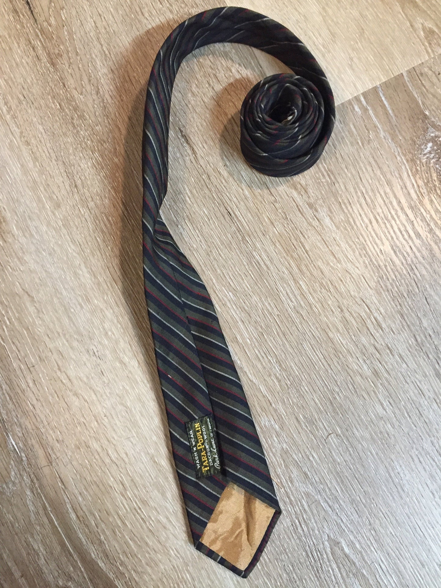 Kingspier Vintage - Tara Poplin by Park Lane of Canada Dacron and wool blend wash n’ wear tie with green, black, red and white stripes.
Length: 56”
Width: 2.5”
This tie is in excellent condition.