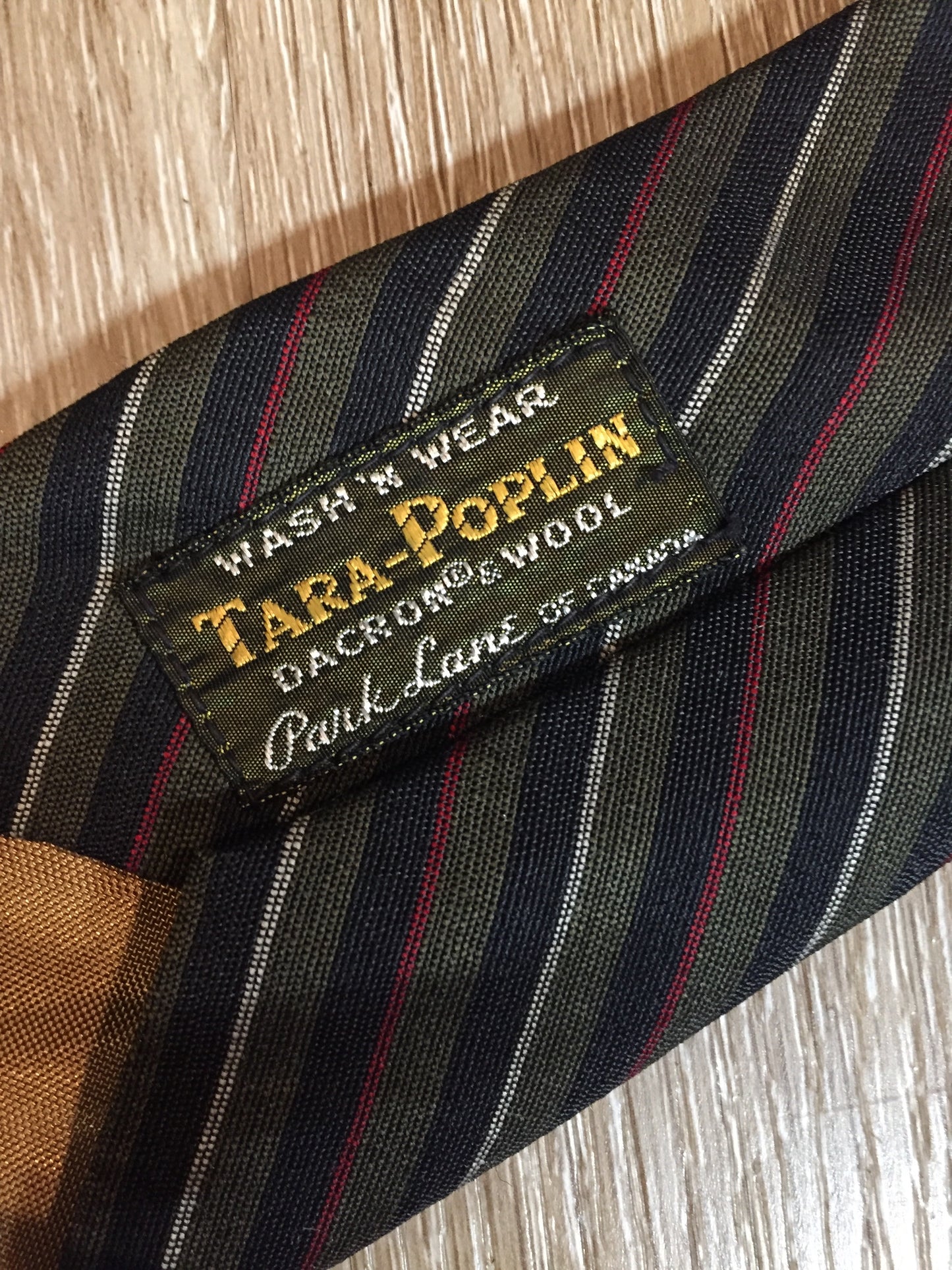 Kingspier Vintage - Tara Poplin by Park Lane of Canada Dacron and wool blend wash n’ wear tie with green, black, red and white stripes.
Length: 56”
Width: 2.5”
This tie is in excellent condition.
