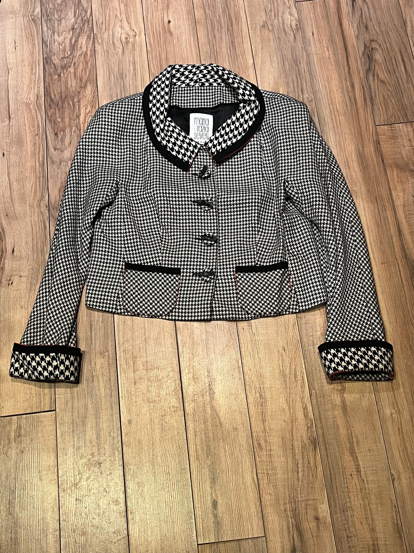 Vintage Maria Grazia Seven wool black and white houndstooth jacket with unique button closures, slight shoulder padding and two front patch pockets.
Made in Italy
Tag reads size 46