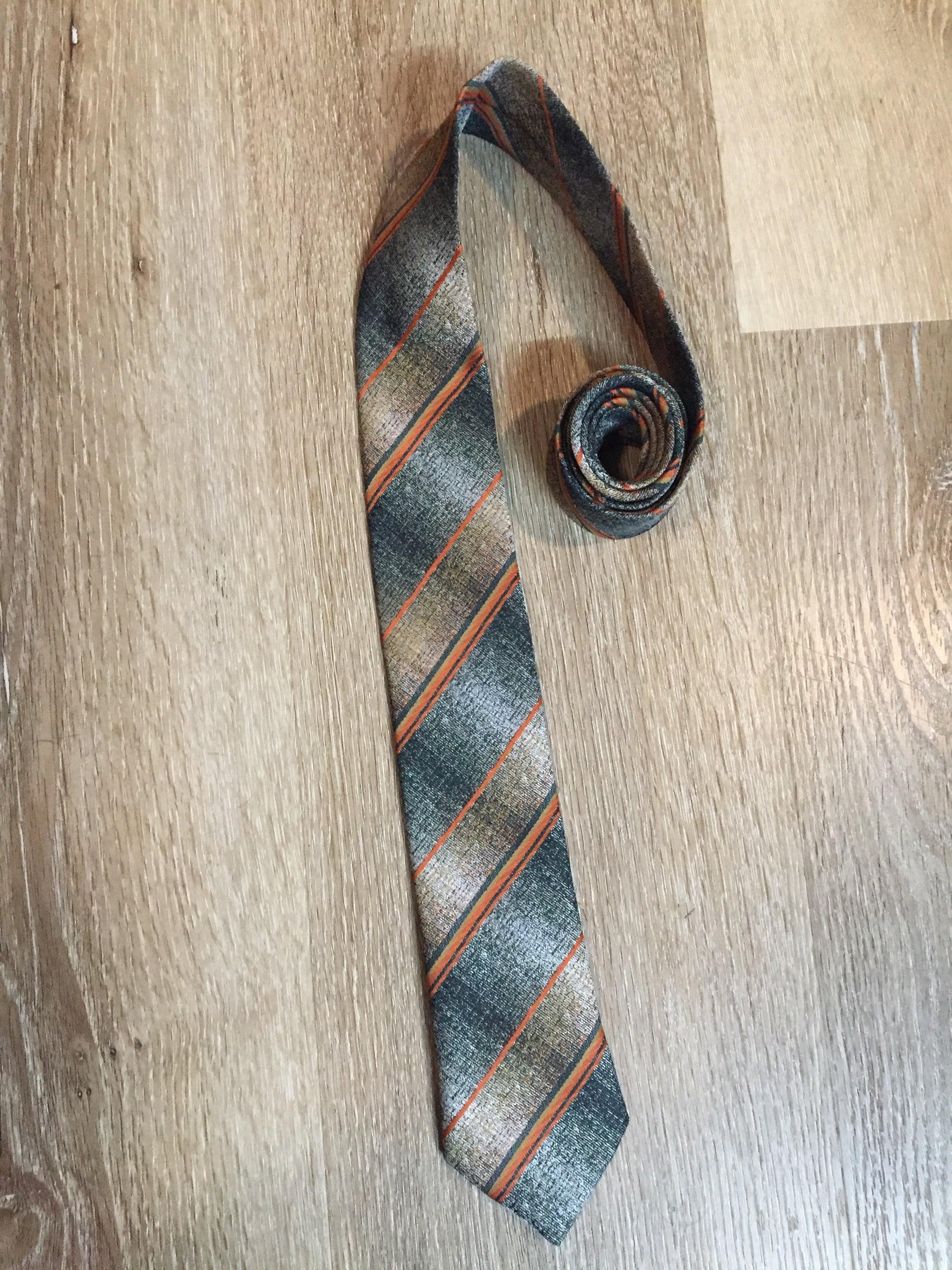 Kingspier Vintage - Hedval 100% polyester tie with silver, mustard, orange and green stripes.
Length: 59”
Width: 2.5” 
This tie is in excellent condition.
