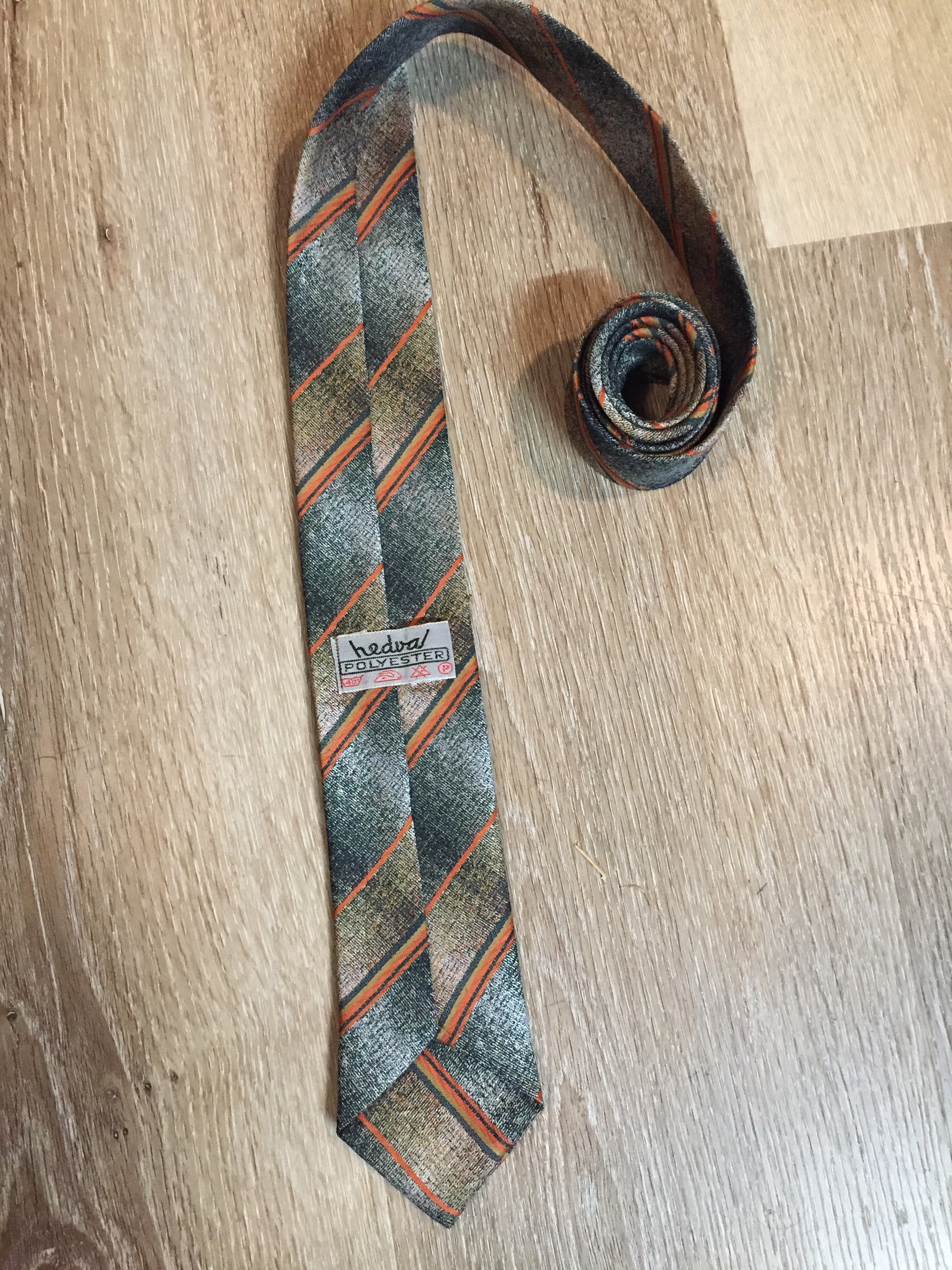 Kingspier Vintage - Hedval 100% polyester tie with silver, mustard, orange and green stripes.
Length: 59”
Width: 2.5” 
This tie is in excellent condition.