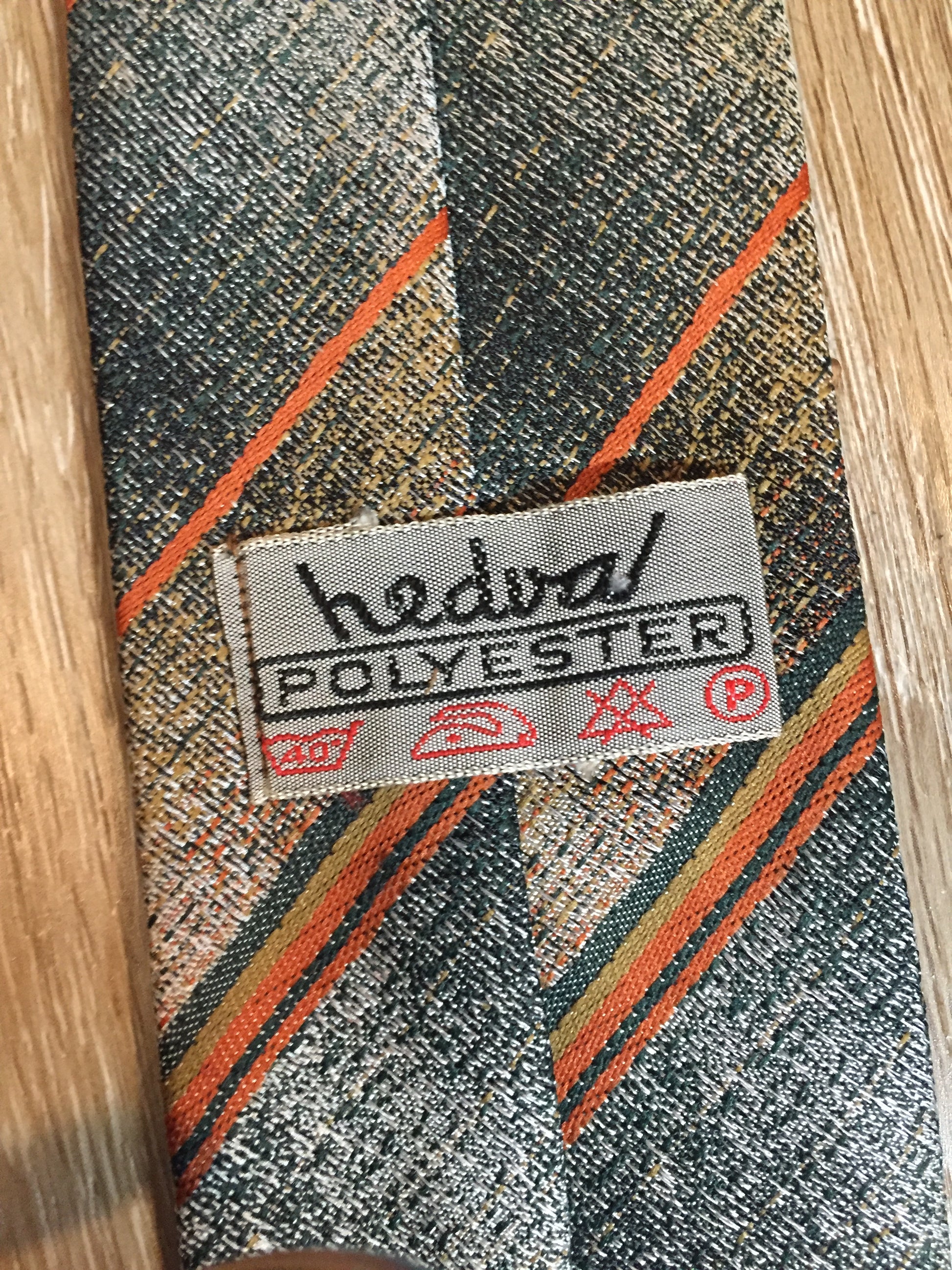 Kingspier Vintage - Hedval 100% polyester tie with silver, mustard, orange and green stripes.
Length: 59”
Width: 2.5” 
This tie is in excellent condition.