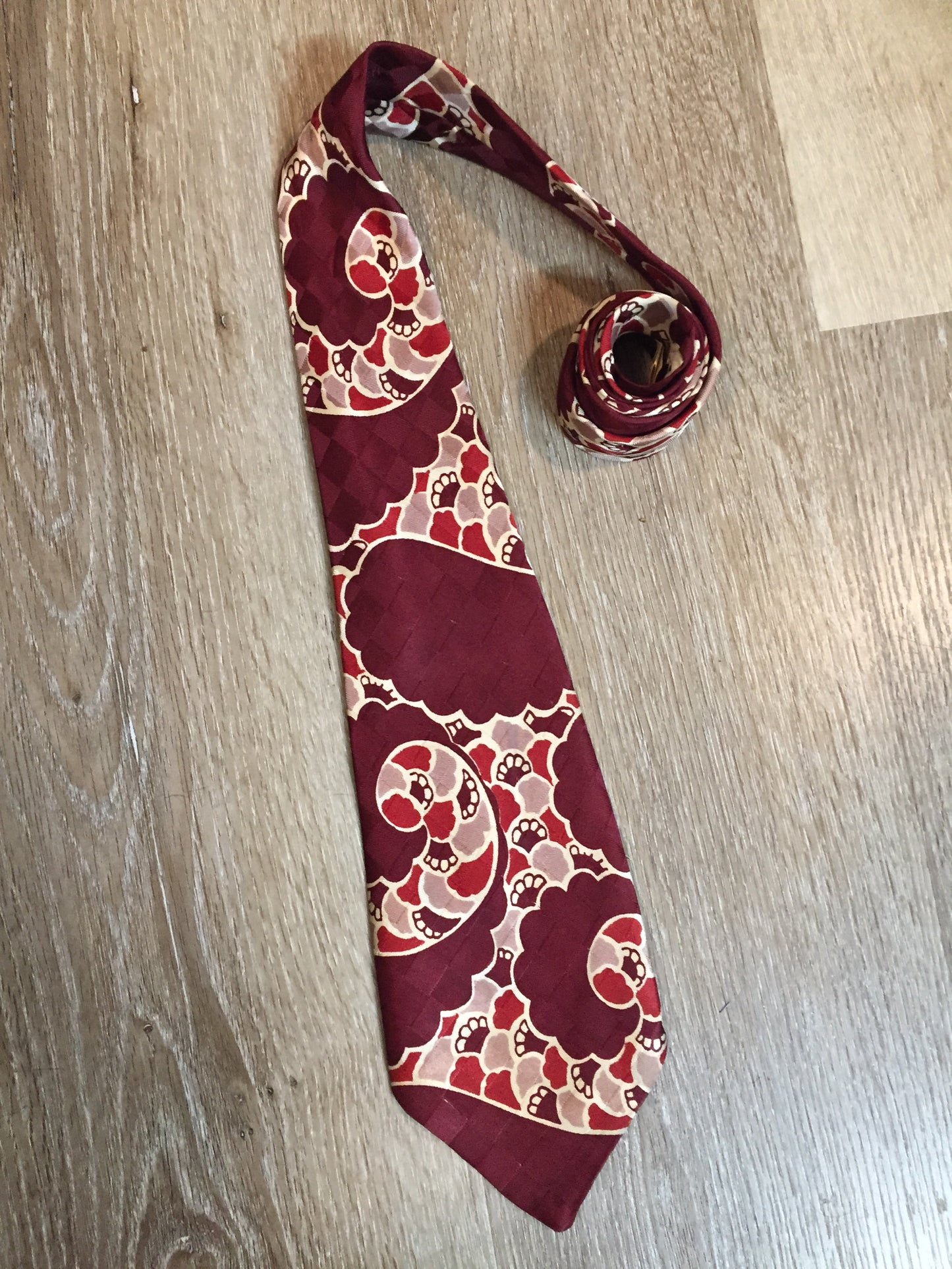 Kingspier Vintage - Van Heussen de Luxe in burgundy, red, cream and brown design on a subtle checkerboard background. Fibres unknown.
Length: 53”
Width: 4”
This tie is in excellent condition.