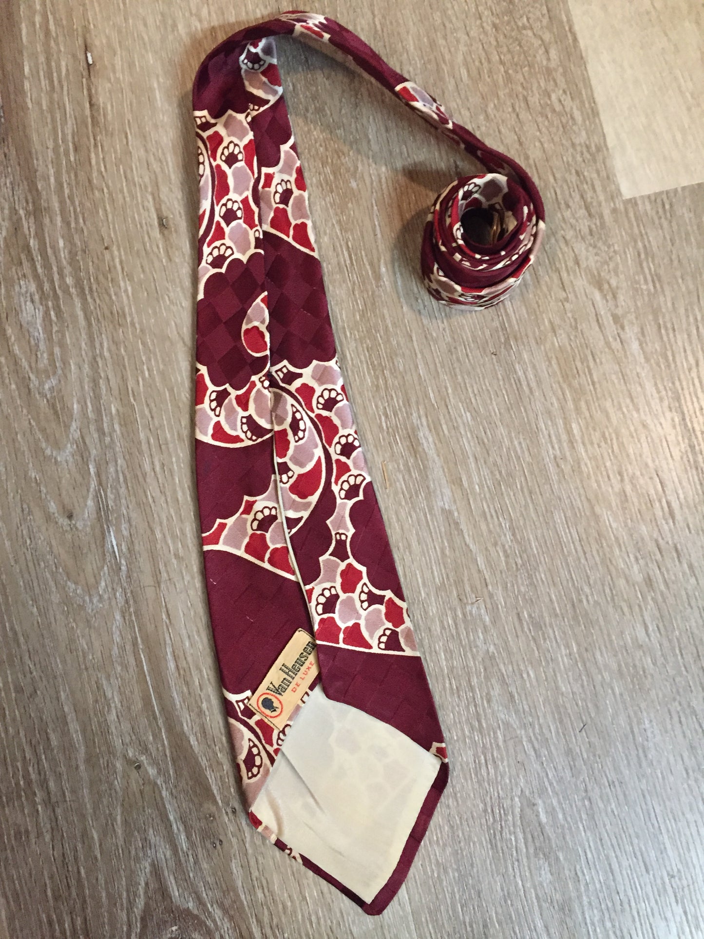 Kingspier Vintage - Van Heussen de Luxe in burgundy, red, cream and brown design on a subtle checkerboard background. Fibres unknown.
Length: 53”
Width: 4”
This tie is in excellent condition.
