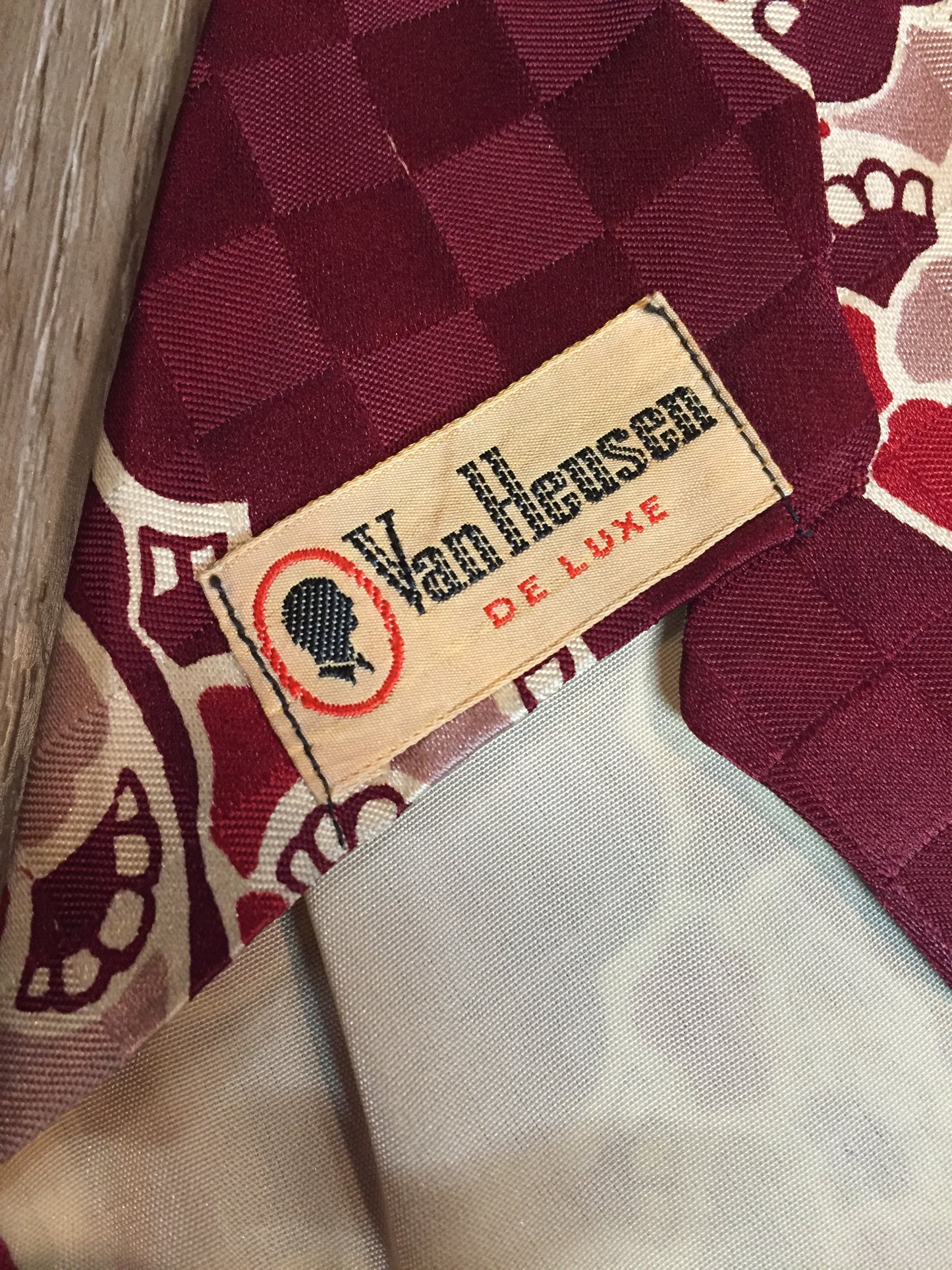 Kingspier Vintage - Van Heussen de Luxe in burgundy, red, cream and brown design on a subtle checkerboard background. Fibres unknown.
Length: 53”
Width: 4”
This tie is in excellent condition.