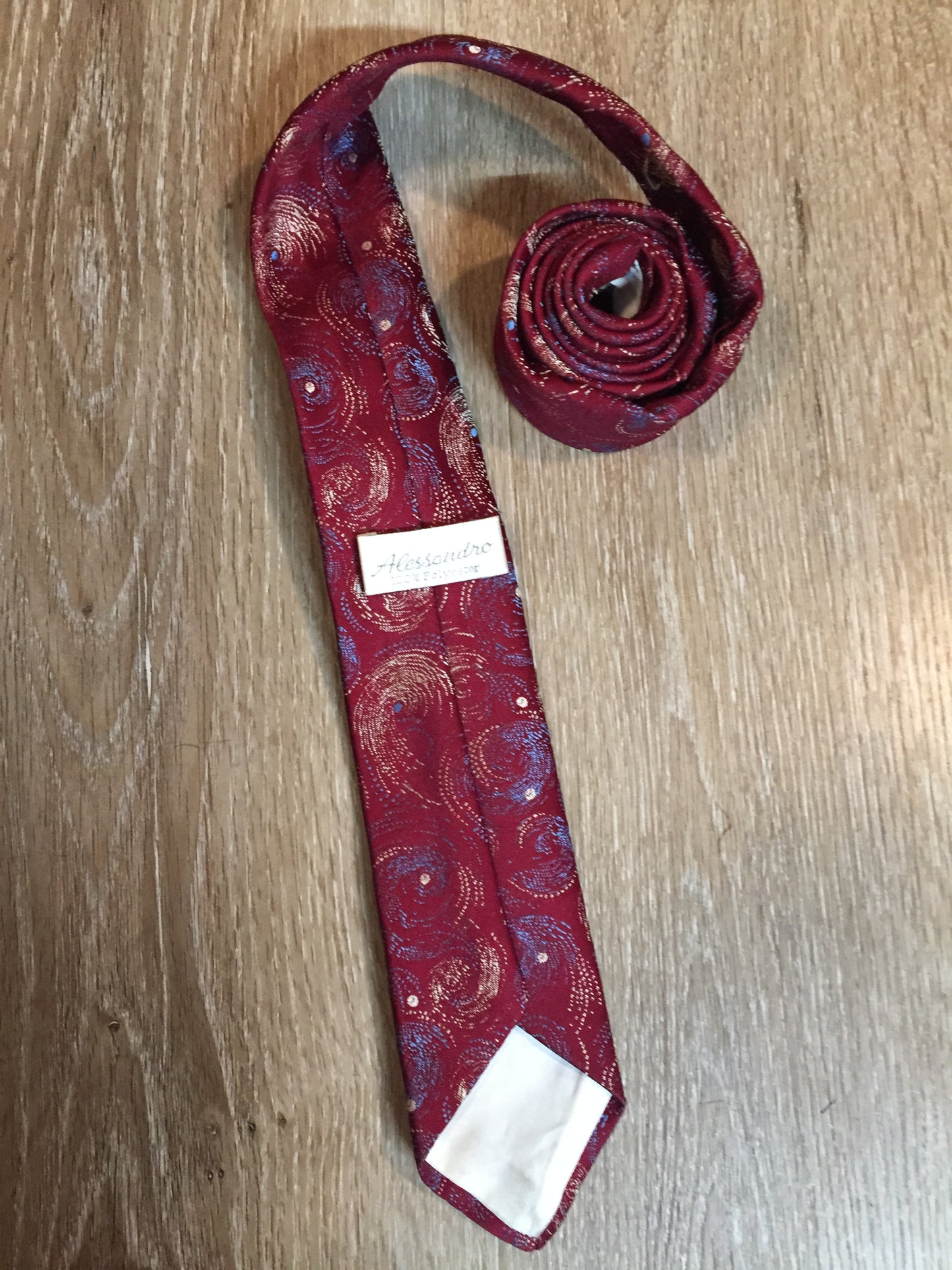 Kingspier Vintage - Alessandro 100% polyester tie with red, blue and cream subtle swirl design.
Length: 56.6”
Width: 2.5” 
This tie is in excellent condition.