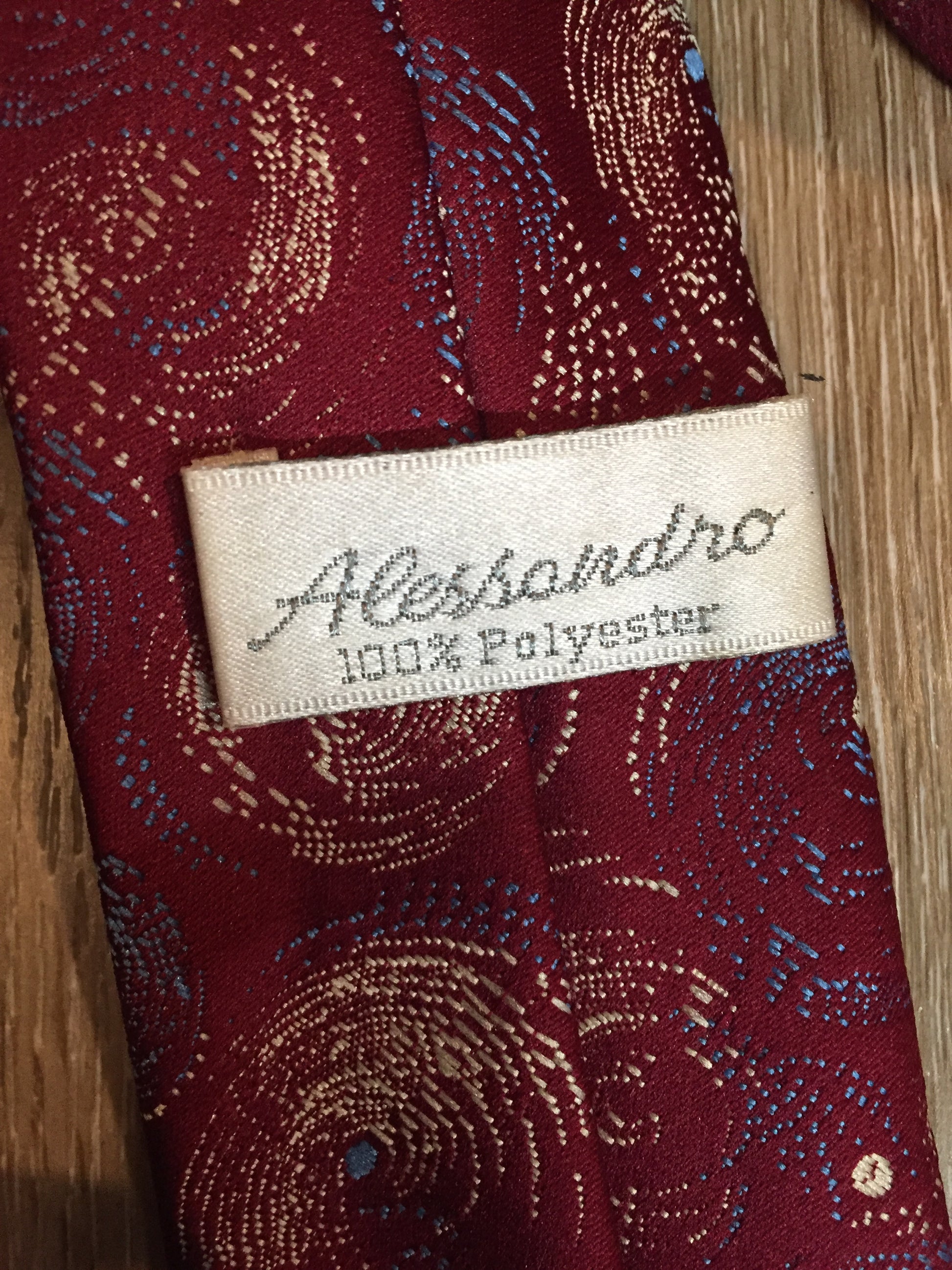 Kingspier Vintage - Alessandro 100% polyester tie with red, blue and cream subtle swirl design.
Length: 56.6”
Width: 2.5” 
This tie is in excellent condition.