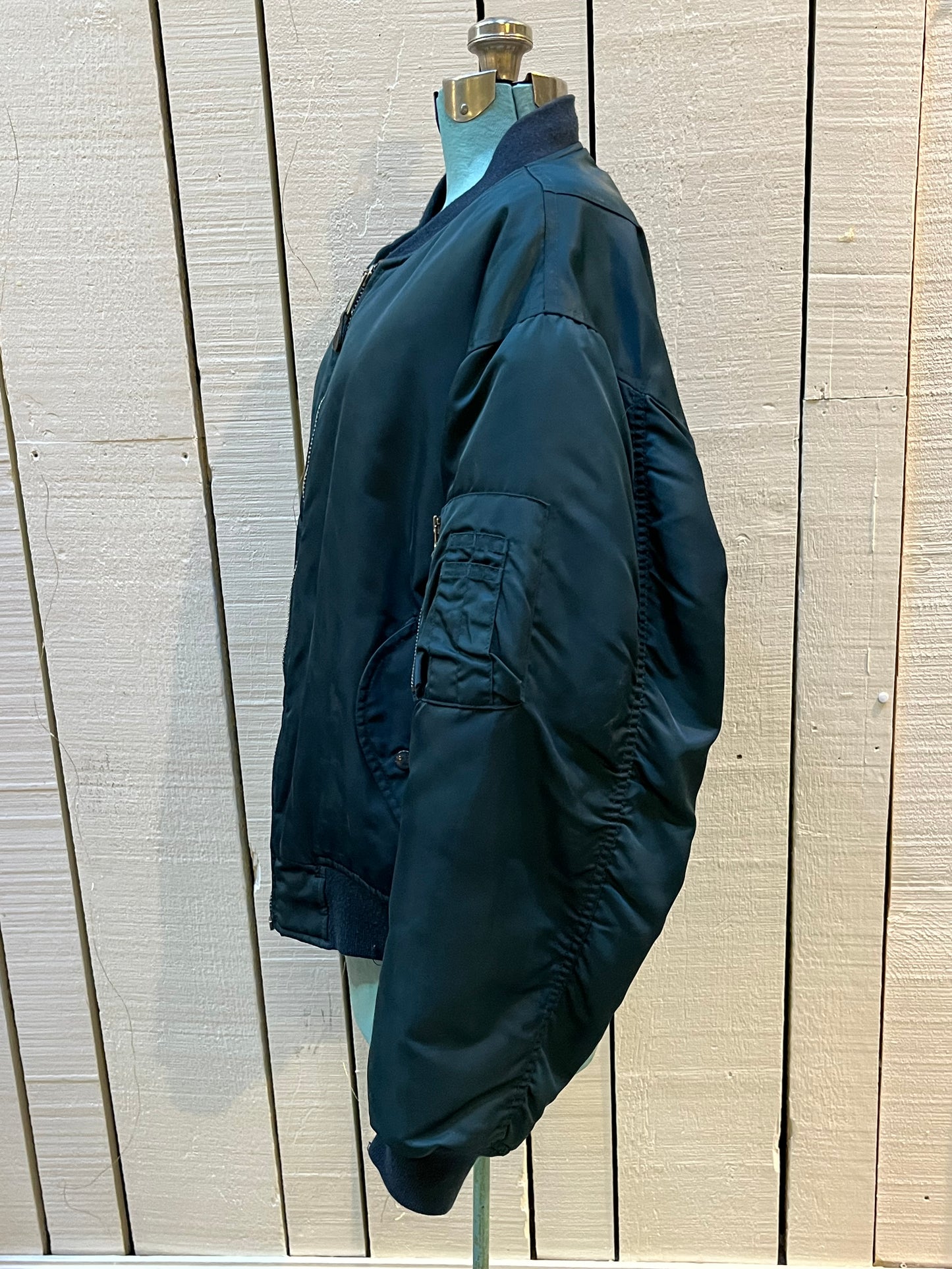 Vintage USAF Cobles Clothing Division Blue Flyer’s Man Intermediate MA. 1 Jacket. Based on original MIL-J-8279E.
100% nylon shell with polyester fill, blaze orange safety lining, zipper closure, two front slash pockets and a pocket on the left arm.
Size Medium
