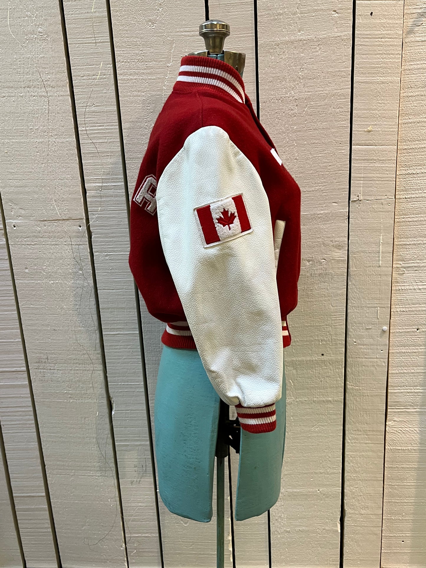 Roots Athletics circa 2000 red and white varsity jacket with wool blend body, leather sleeves, snap closures, two front slash pockets, “R” patch on the chest, Canada flag patch on the arm, “00” patch on the arm and “Canada” written across the back.
Made in Canada
Size Youth Medium