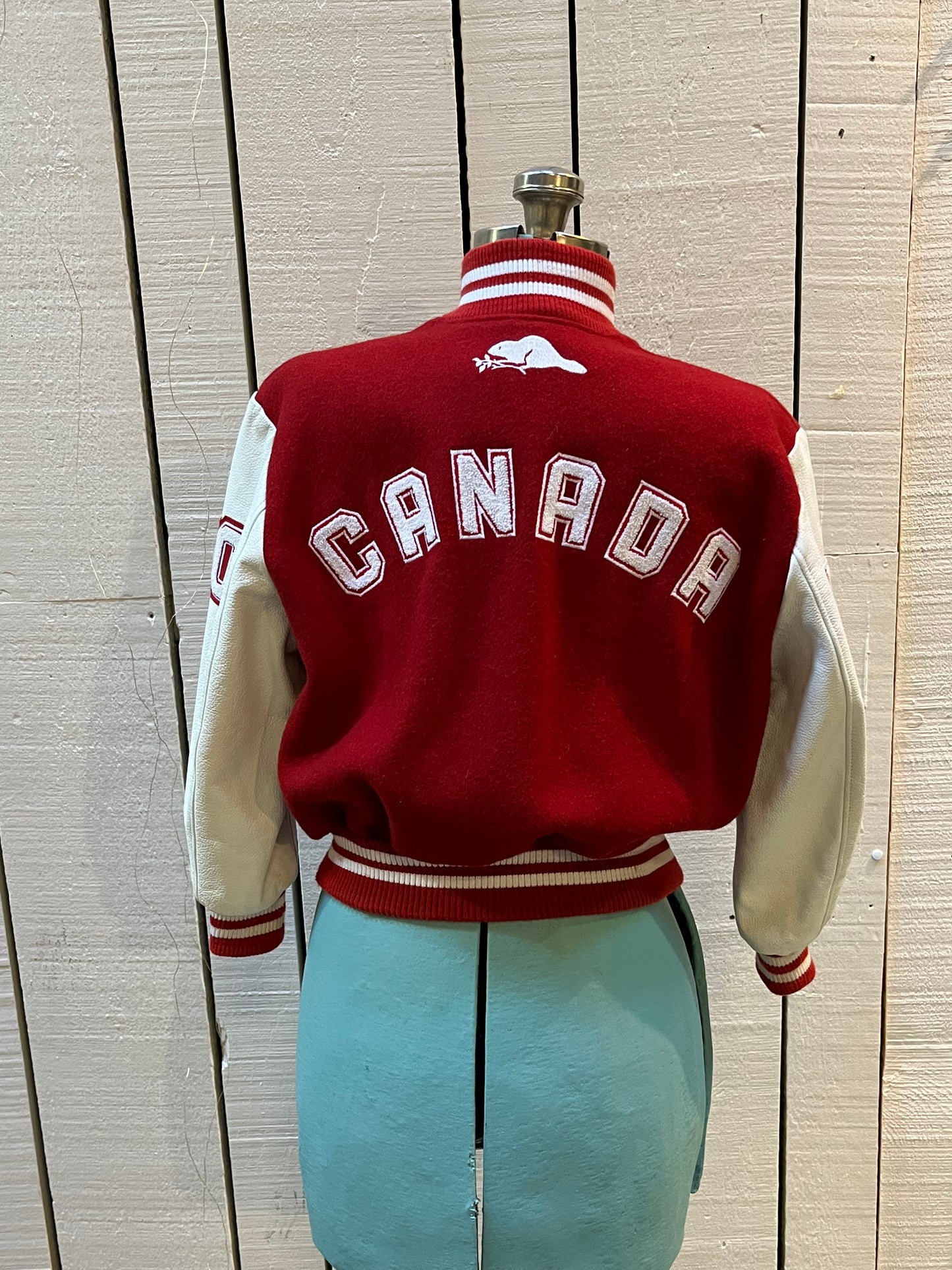 Roots Athletics circa 2000 red and white varsity jacket with wool blend body, leather sleeves, snap closures, two front slash pockets, “R” patch on the chest, Canada flag patch on the arm, “00” patch on the arm and “Canada” written across the back.
Made in Canada
Size Youth Medium
