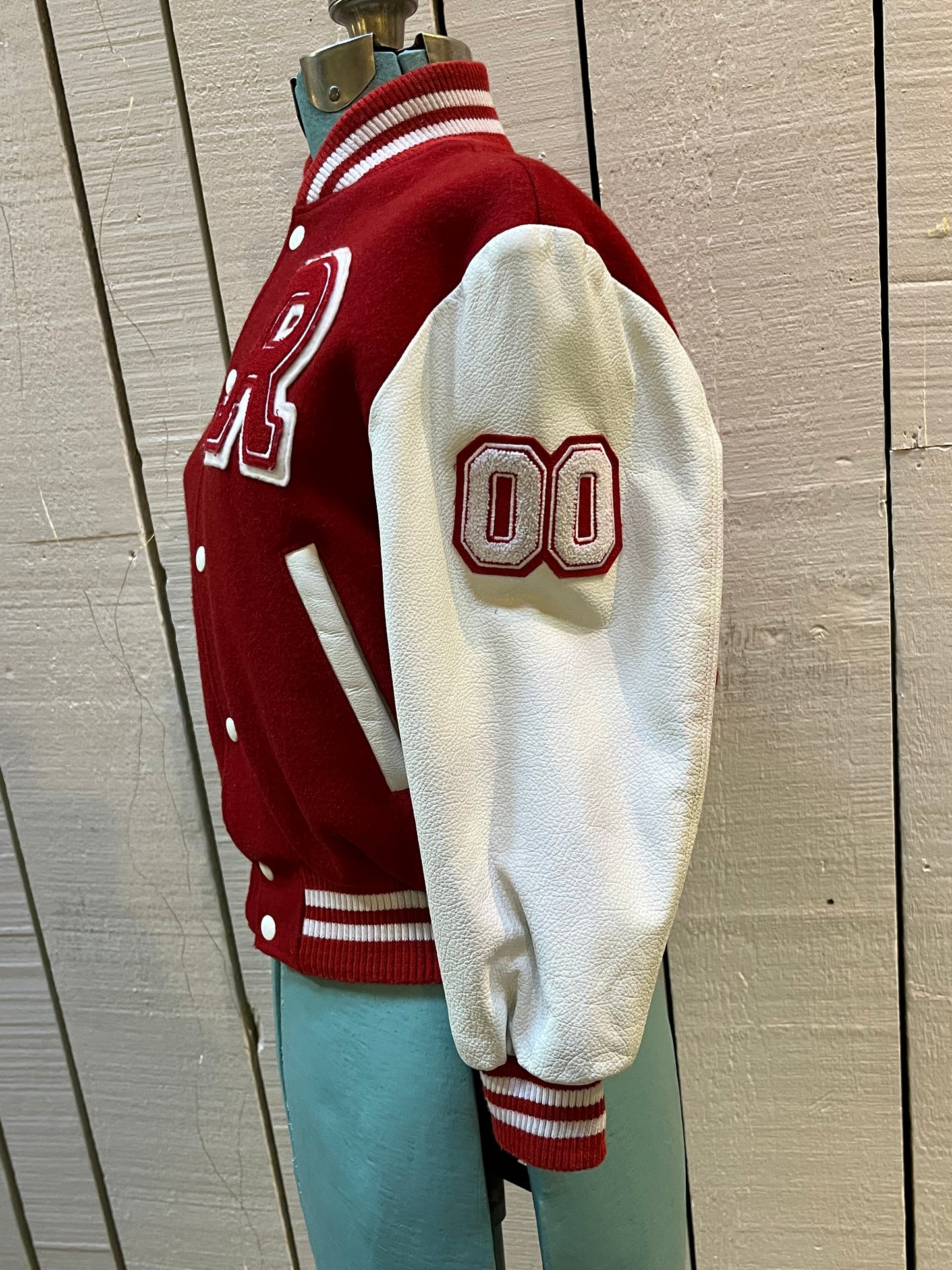 Roots Athletics circa 2000 red and white varsity jacket with wool blend body, leather sleeves, snap closures, two front slash pockets, “R” patch on the chest, Canada flag patch on the arm, “00” patch on the arm and “Canada” written across the back.
Made in Canada
Size Youth Medium