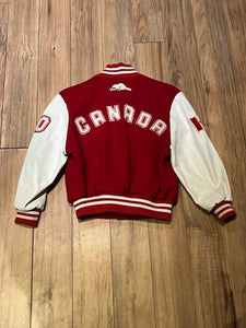 Roots Athletics circa 2000 red and white varsity jacket with wool blend body, leather sleeves, snap closures, two front slash pockets, “R” patch on the chest, Canada flag patch on the arm, “00” patch on the arm and “Canada” written across the back.

Made in Canada
Size Youth Medium