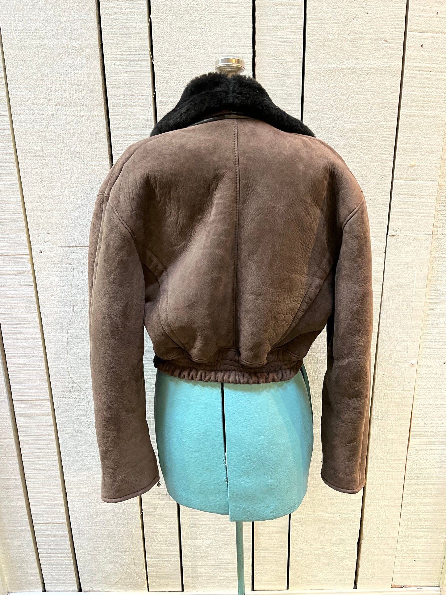 Vintage O’Ned chocolate brown sheepskin shearling cropped flight jacket, with snap closures, zip details on the cuffs, two front pockets and a belt at the waist.
Made in France
Chest 40”