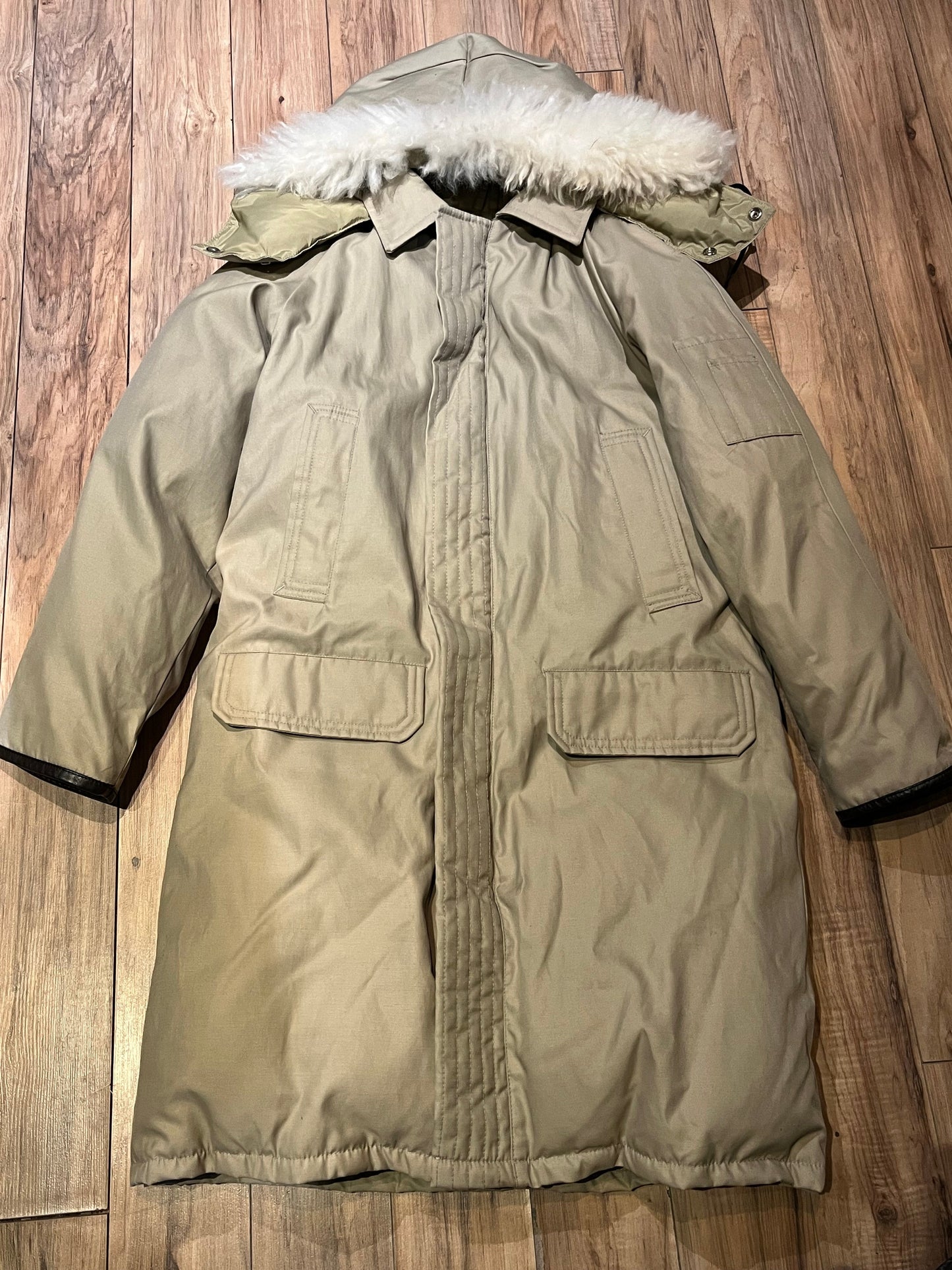 Vintage Sears “The Mens Store” beige down-filled parka (60% duck down/ 40% waterfowl feather) with cotton/nylon blend shell, zipper and button closures, two hand-warmer pockets, two flap pockets, two inside zip pockets, hood with fur trim and storm cuffs.
Made in Canada
Size Small 34-36