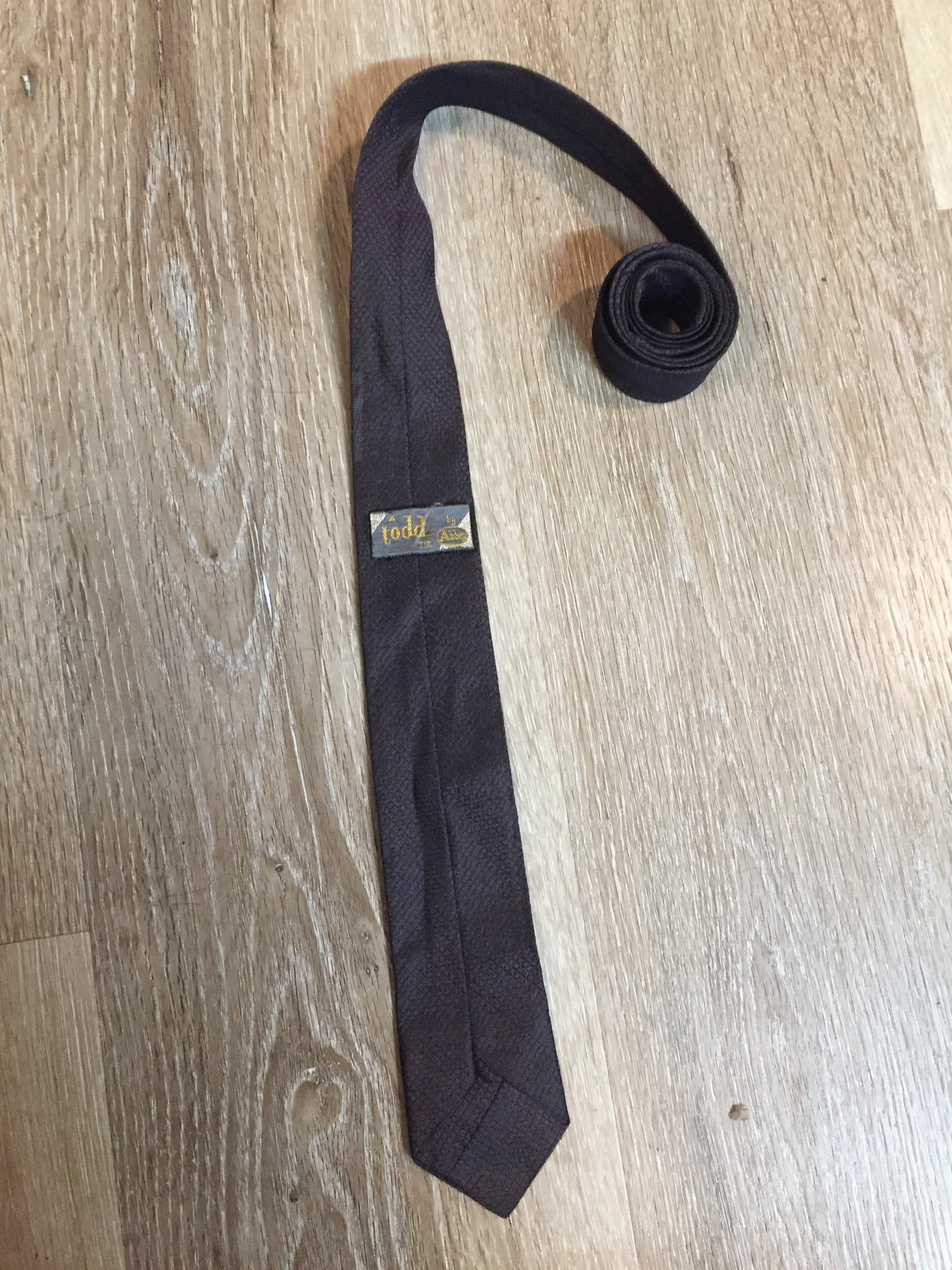 Kingspier Vintage - A Todd by Abbey tie with brown and black design. Fibres unknown.
Length: 56”
Width: 2.5”
This tie is in excellent condition.