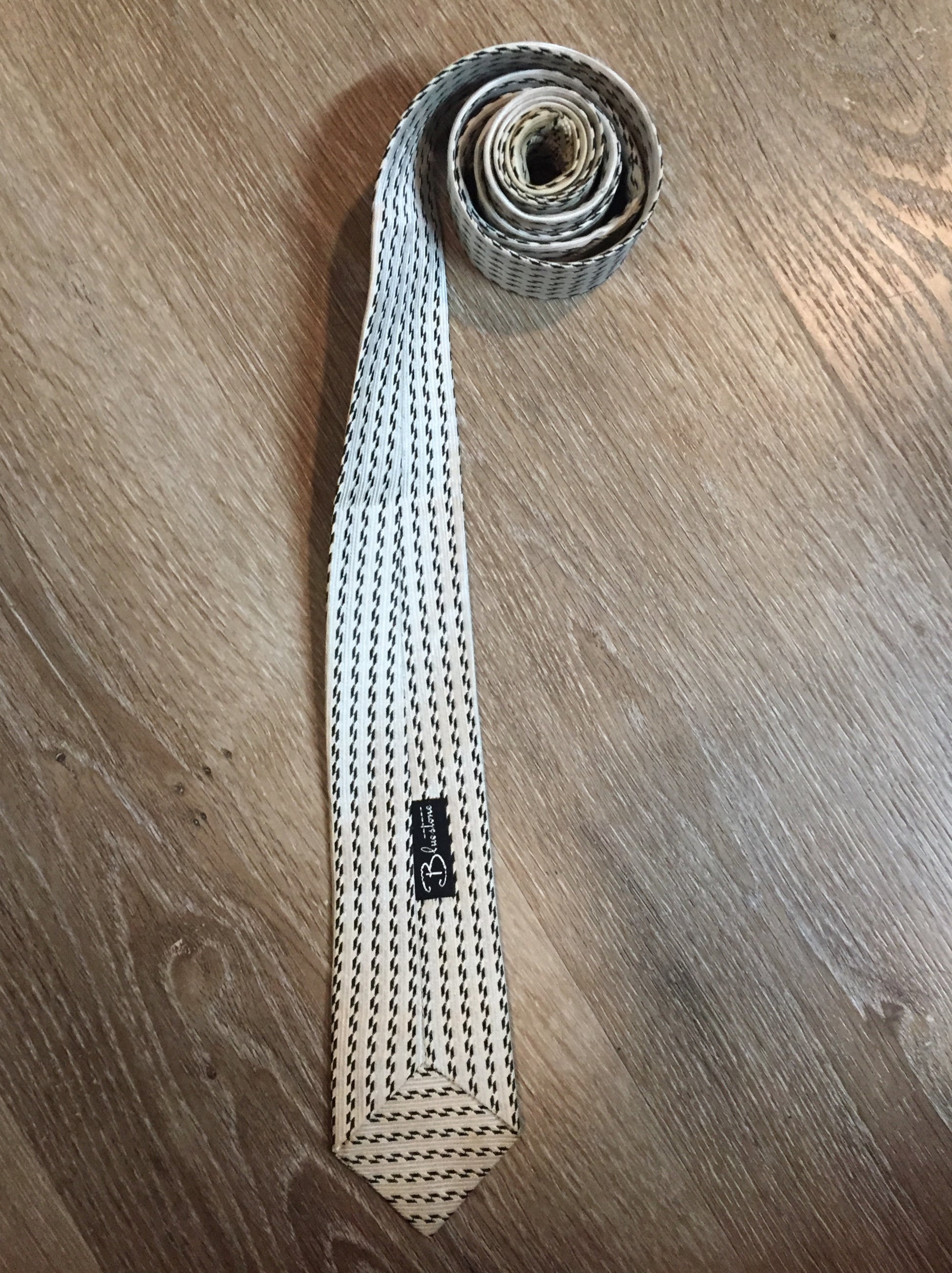 Kingspier Vintage - Bluestone white and black pattern tie. Fibres unknown.
Length: 56.25”
Width: 7.5” 
This tie is in great condition with some slight yellowing.