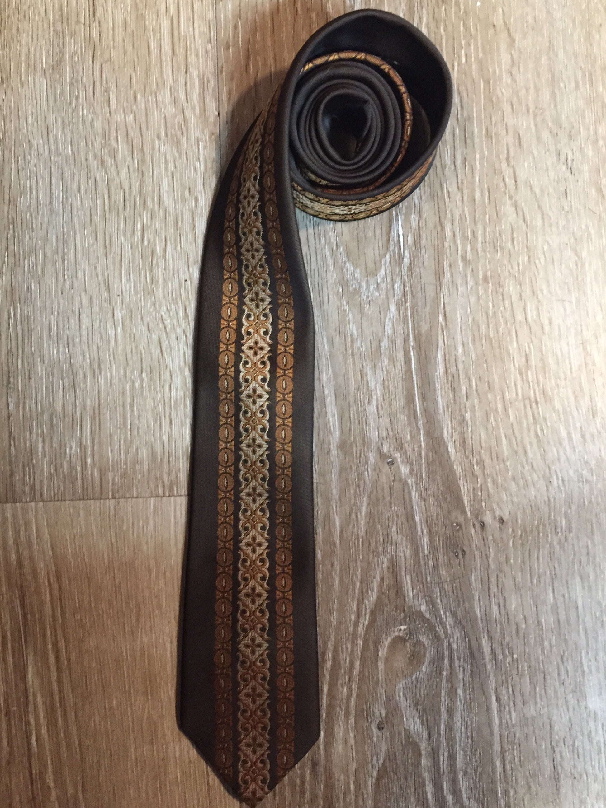 Kingspier Vintage - Albersia brown and orange 70’s pattern tie. Fibres unknown.
Length: 52.25” 
Width: 2.25” 
This tie is in excellent condition.