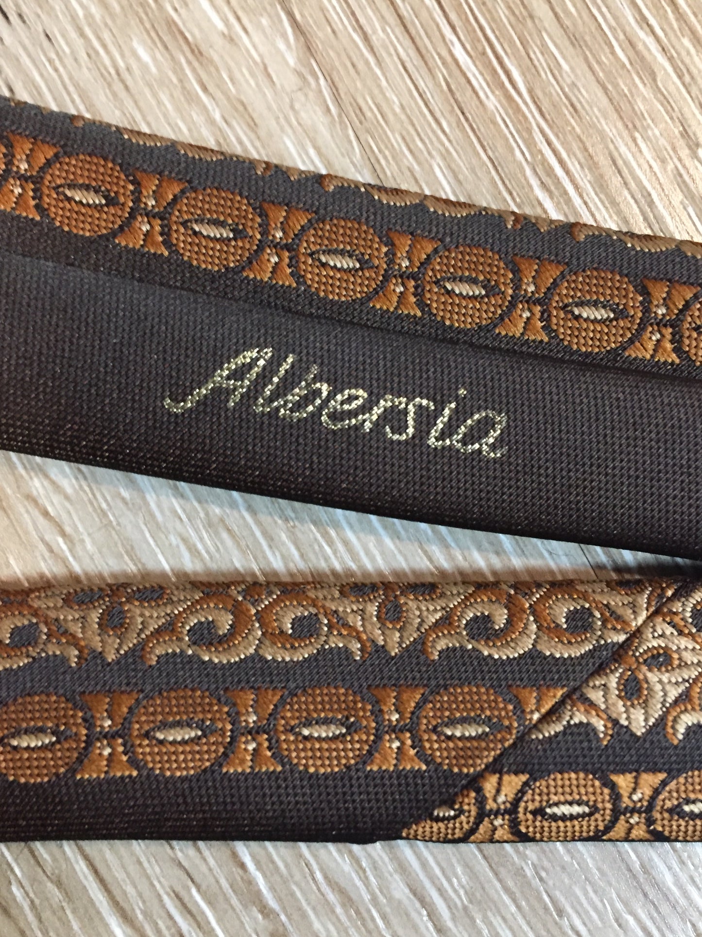 Kingspier Vintage - Albersia brown and orange 70’s pattern tie. Fibres unknown.
Length: 52.25” 
Width: 2.25” 
This tie is in excellent condition.