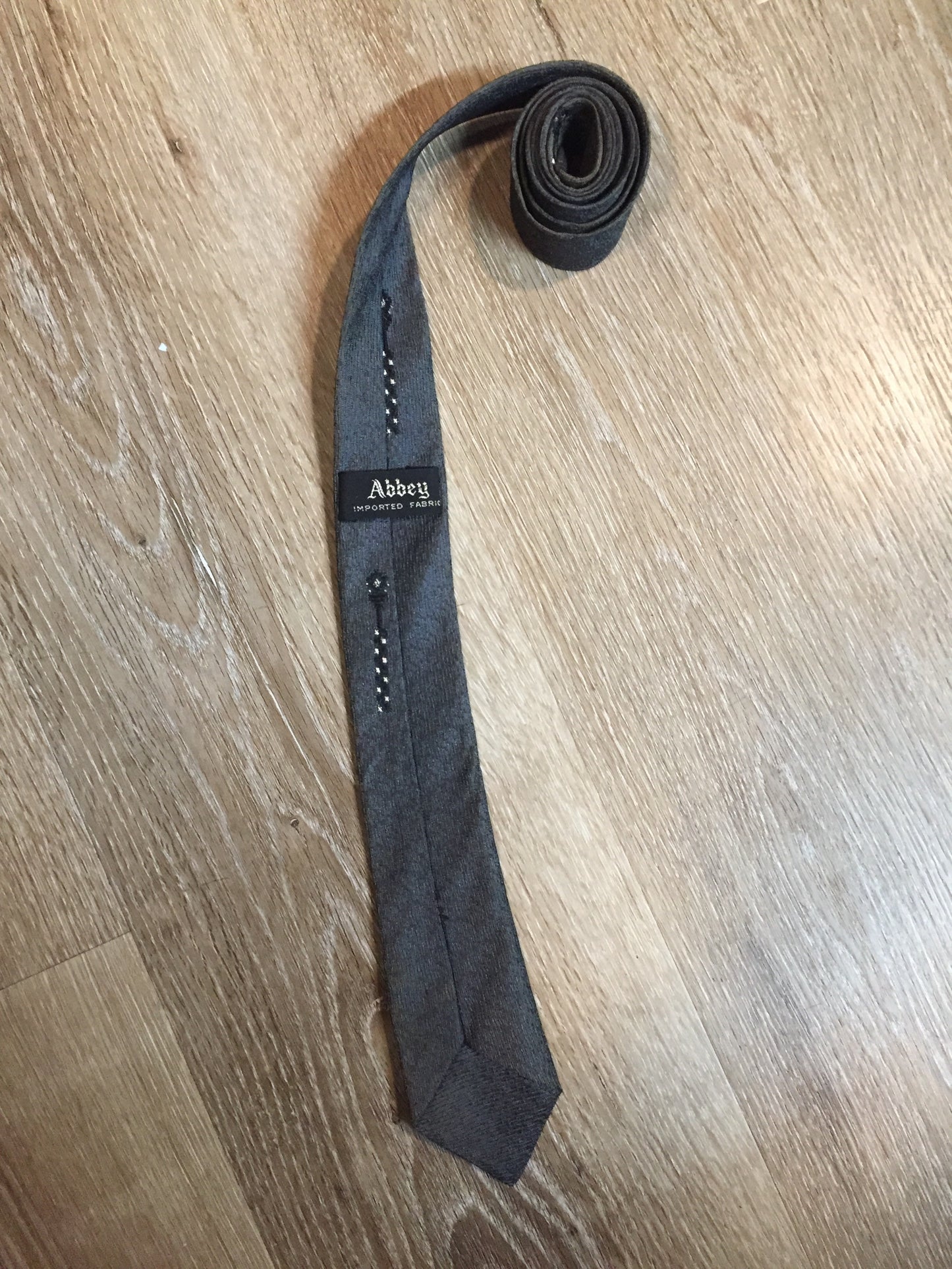 Kingspier Vintage - Abbey tie with grey, black and white pattern. Fibres unknown.
Length: 56” 
Width: 2.25” 
This tie is in excellent condition with some yellowing/ sun damage.