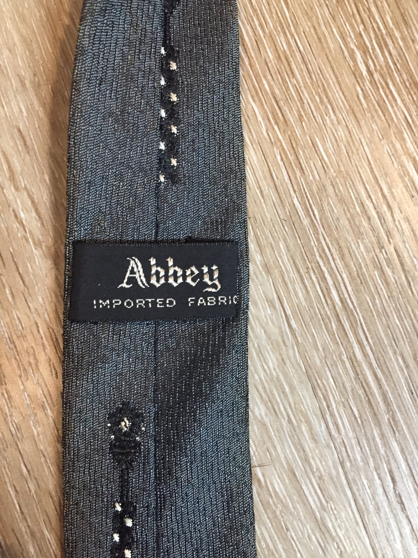 Kingspier Vintage - Abbey tie with grey, black and white pattern. Fibres unknown.
Length: 56” 
Width: 2.25” 
This tie is in excellent condition with some yellowing/ sun damage.