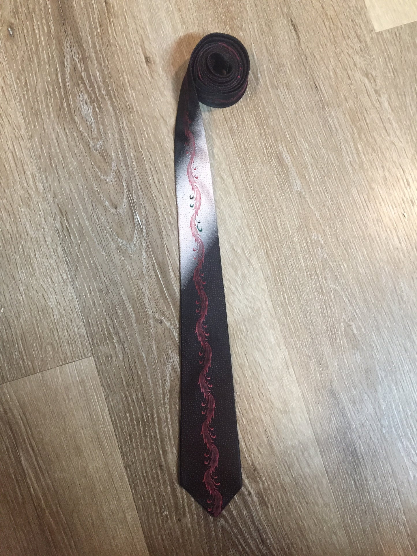 Kingspier Vintage - Bluestone tie in black, pink, white and green with abstract feather design.
Length: 59”
Width: 2.25”
This tie is in excellent condition.