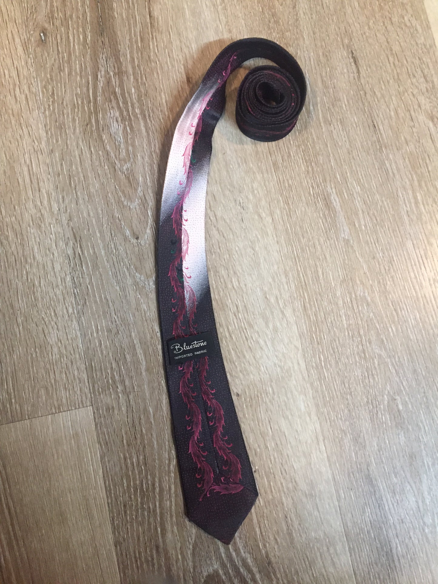 Kingspier Vintage - Bluestone tie in black, pink, white and green with abstract feather design.
Length: 59”
Width: 2.25”
This tie is in excellent condition.