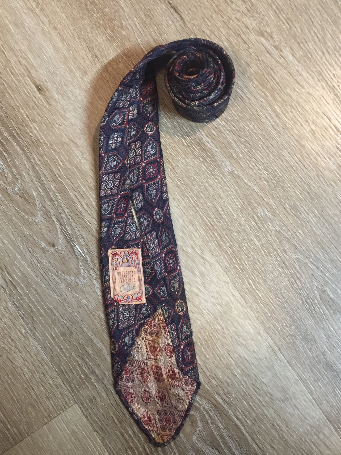 Kingspier Vintage - Currie “Authentic Ancient Persians” with navy, red and cream design. Fibres unknown but feels like sIlk.
Length: 51.5”
Width: 3”
This tie is in great condition with some minor wear.