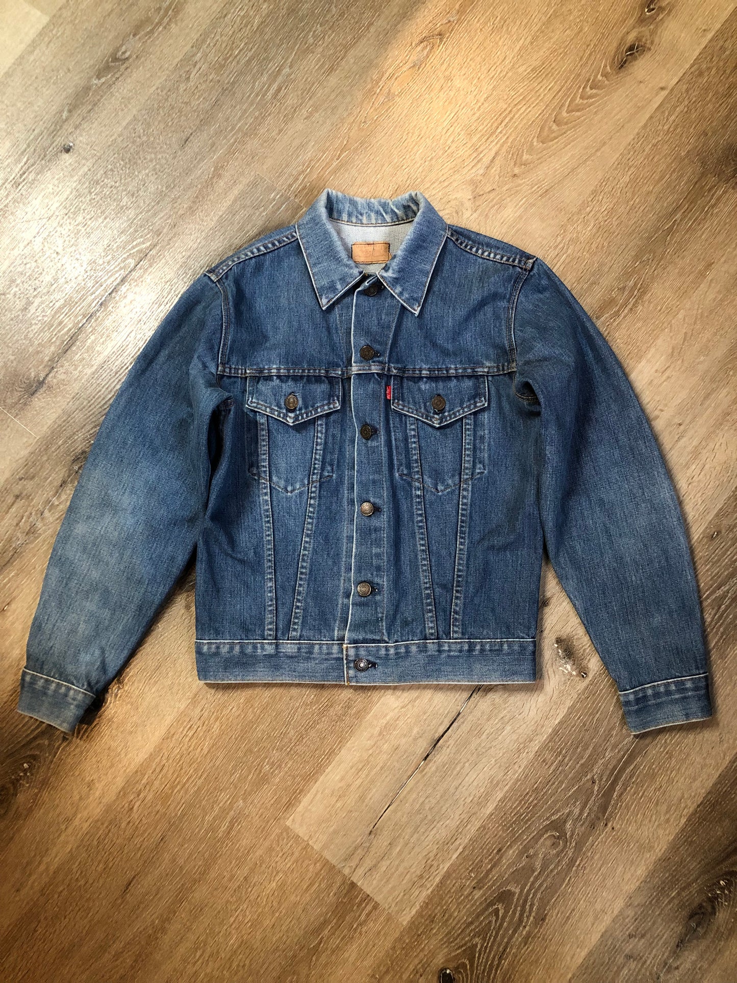 Vintage 1970’s Levi’s medium wash denim trucker jacket with button closures and two flap pockets on the chest. Red Tab, 100% cotton, made in USA, size 18 - Kingspier Vintage