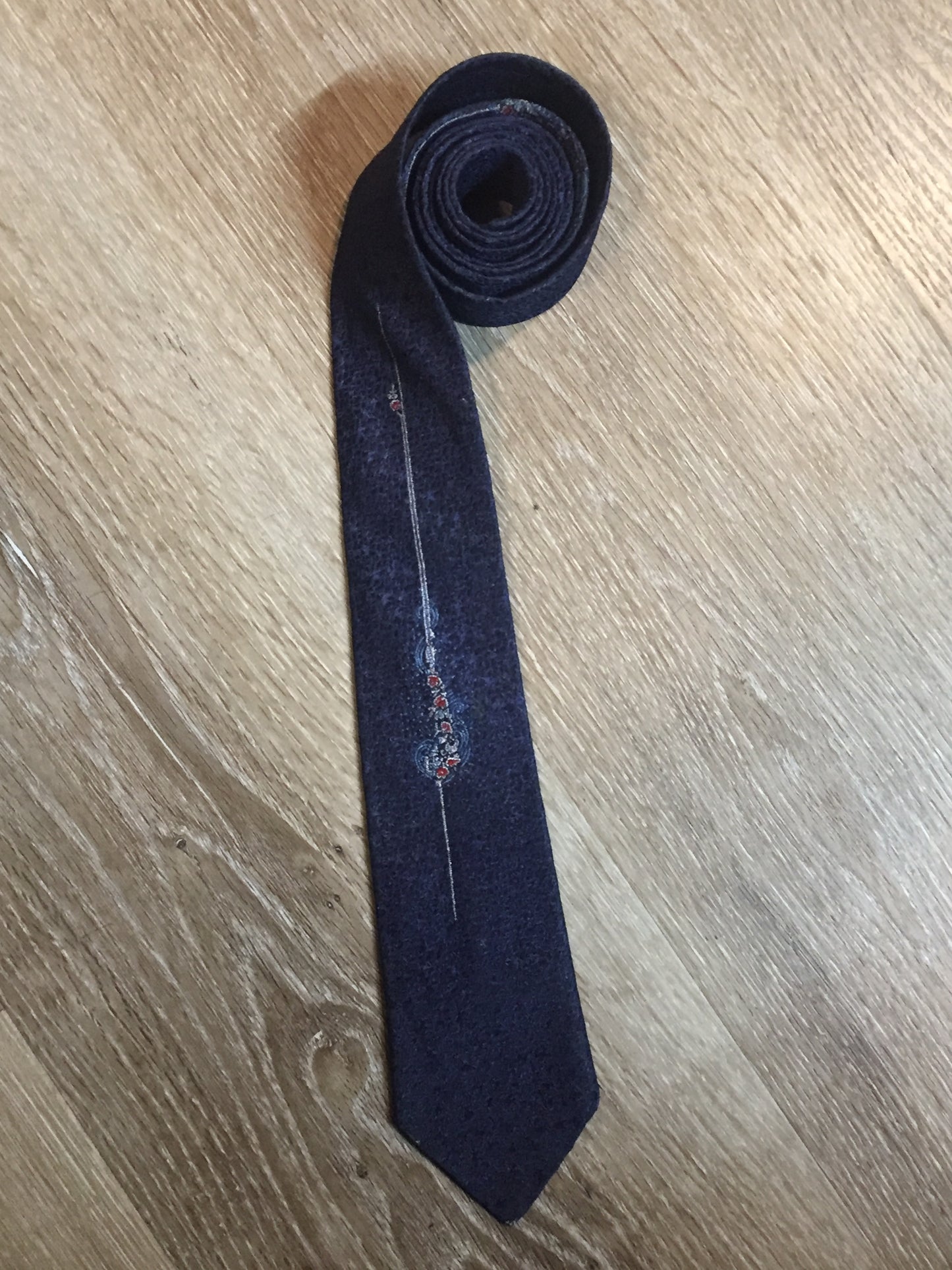 Kingspier Vintage - Vintage dark blue tie with white, light blue and red flower motif. Fibres unknown.
Length: 54.25”
Width: 2.5”
This tie is in excellent condition.