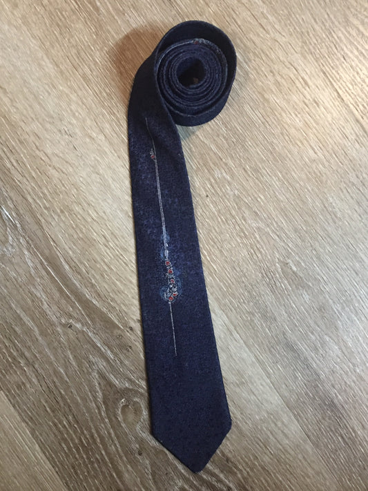 Kingspier Vintage - Vintage dark blue tie with white, light blue and red flower motif. Fibres unknown.
Length: 54.25”
Width: 2.5” 
This tie is in excellent condition.