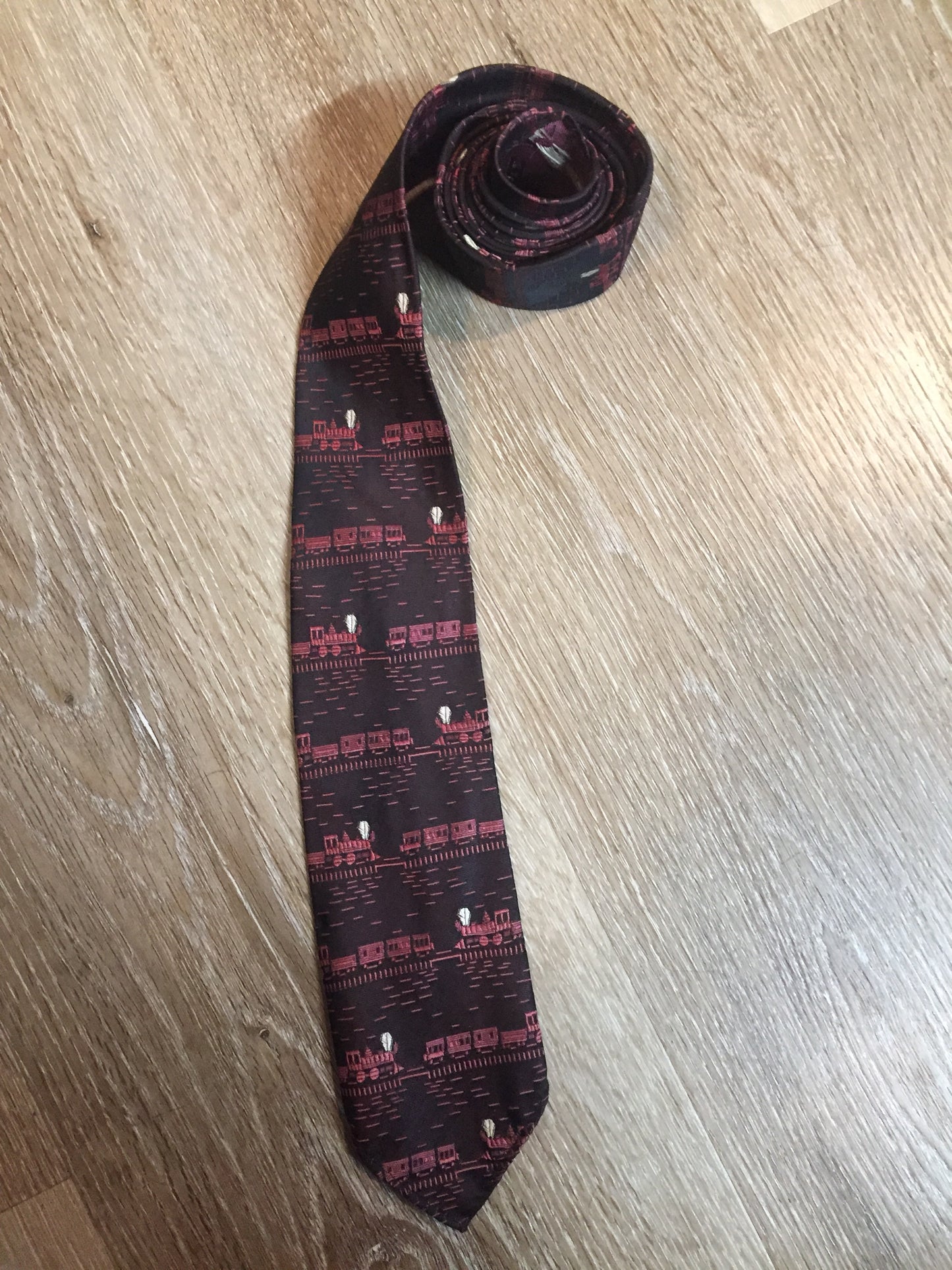 Kingspier Vintage - Berkley “Smoothie” pink and black tie with a train pattern. Fibres unknown.
Length: 58”
Width: 2.5”
This tie is in excellent condition.