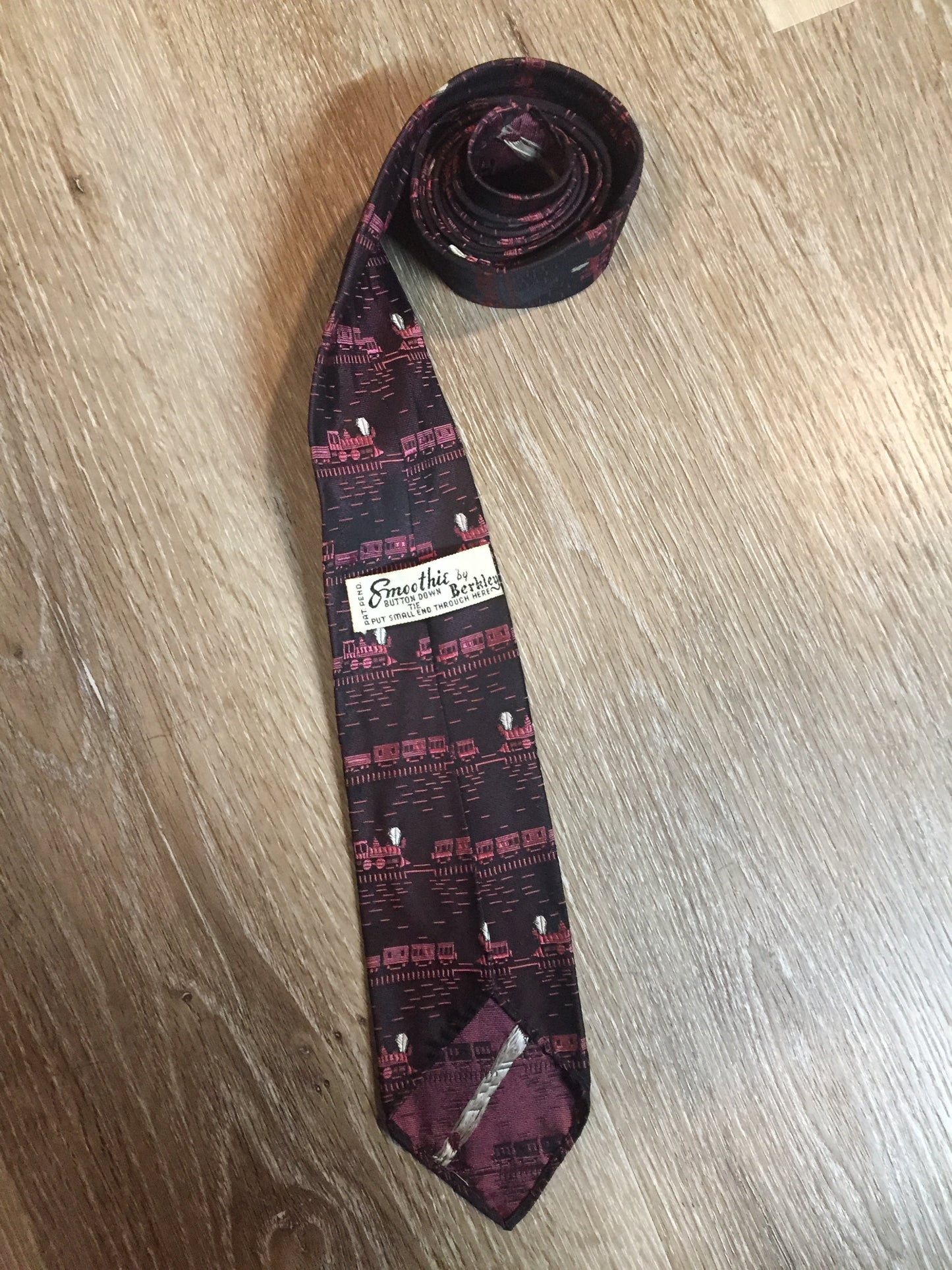 Kingspier Vintage - Berkley “Smoothie” pink and black tie with a train pattern. Fibres unknown.
Length: 58”
Width: 2.5”
This tie is in excellent condition.